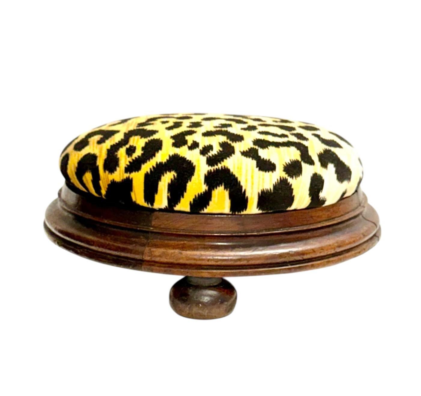 Encantador escabel inglés de madera del siglo XIX, tapizado en terciopelo de leopardo de Clarence House de época. La forma redondeada, las proporciones clásicas y la cálida pátina de la madera combinan a la perfección con el atrevido textil de alta