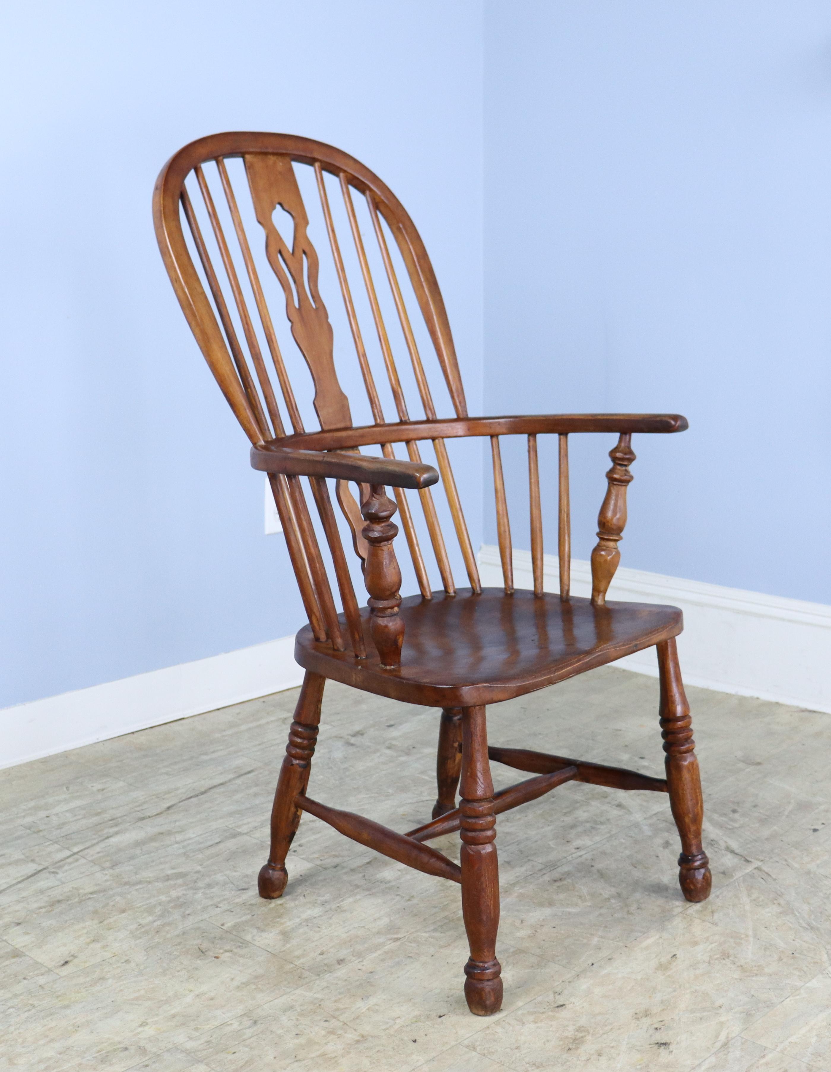 Une chaise Windsor classique en bois fruitier, sculptée à la main et raffinée. L'éclisse en forme de dos de violon rappelle les courbes d'un violon, typiques du style Queen Anne, bien que cette pièce date du milieu du XIXe siècle, donc d'une époque