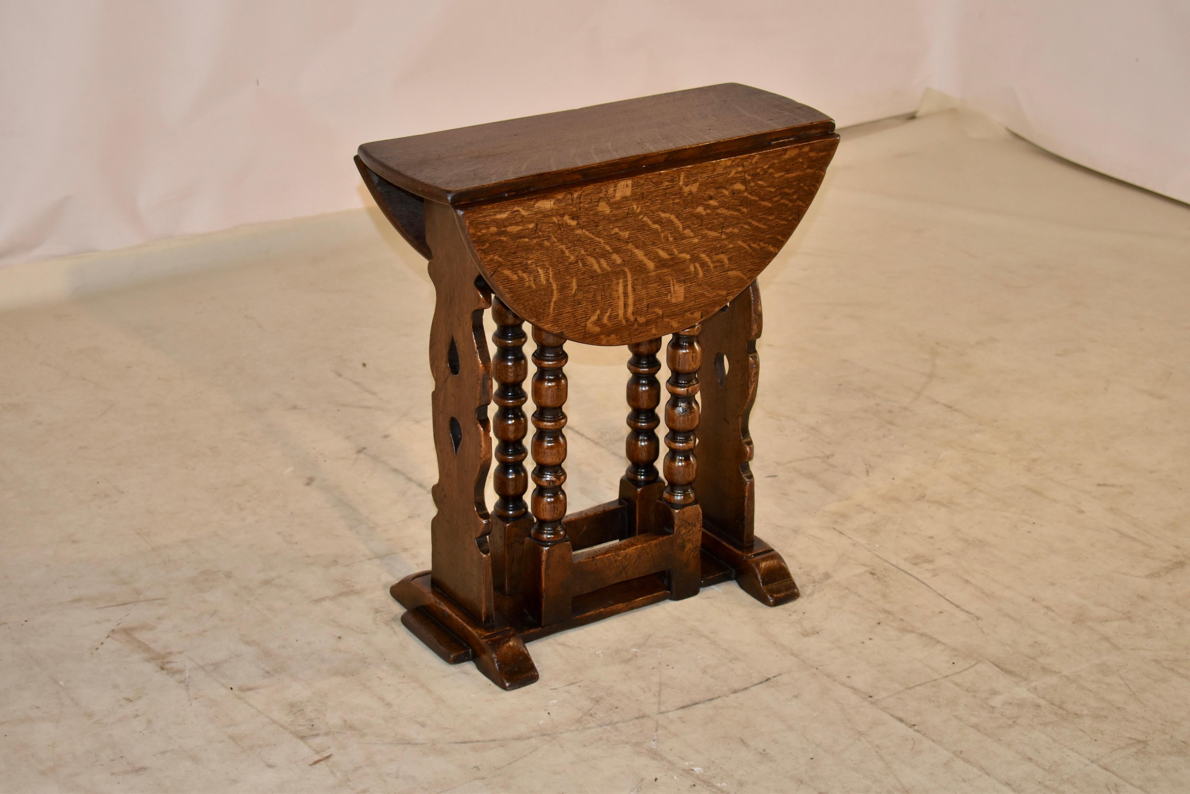 19th century oak gate leg table from England. The top is wonderfully grained and follows down to a pierced trestle base with lovely hand turned bob and stop style legs, which swing out to support the leaves when extended. The top open measures 24.63