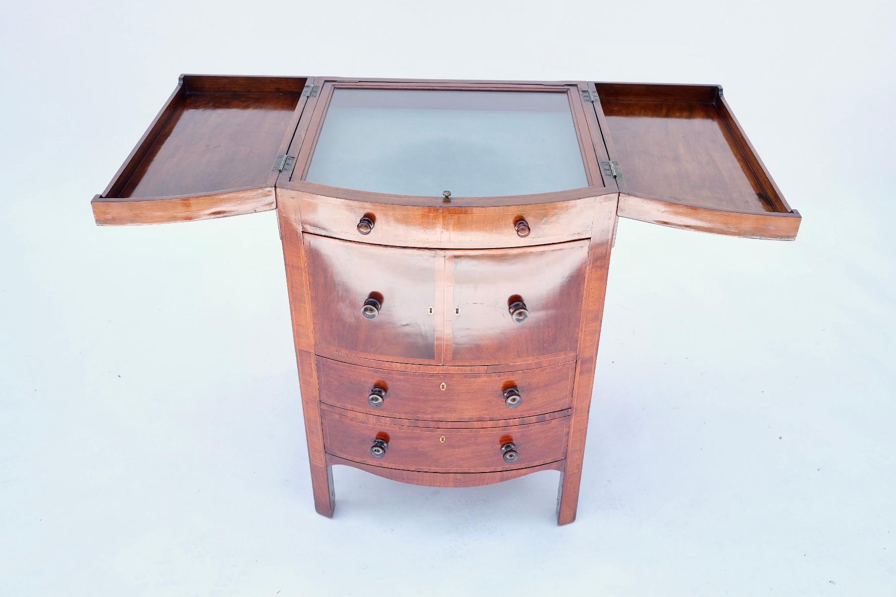 19th century. English. Mahogany. Chest opens up into a vanity. Glass top allows viewing of gentleman's accessories. Operable drawers for storage. Excellent condition. With the chest opened, the full width is 45 inches. Closed width is 22 1/4 inches.