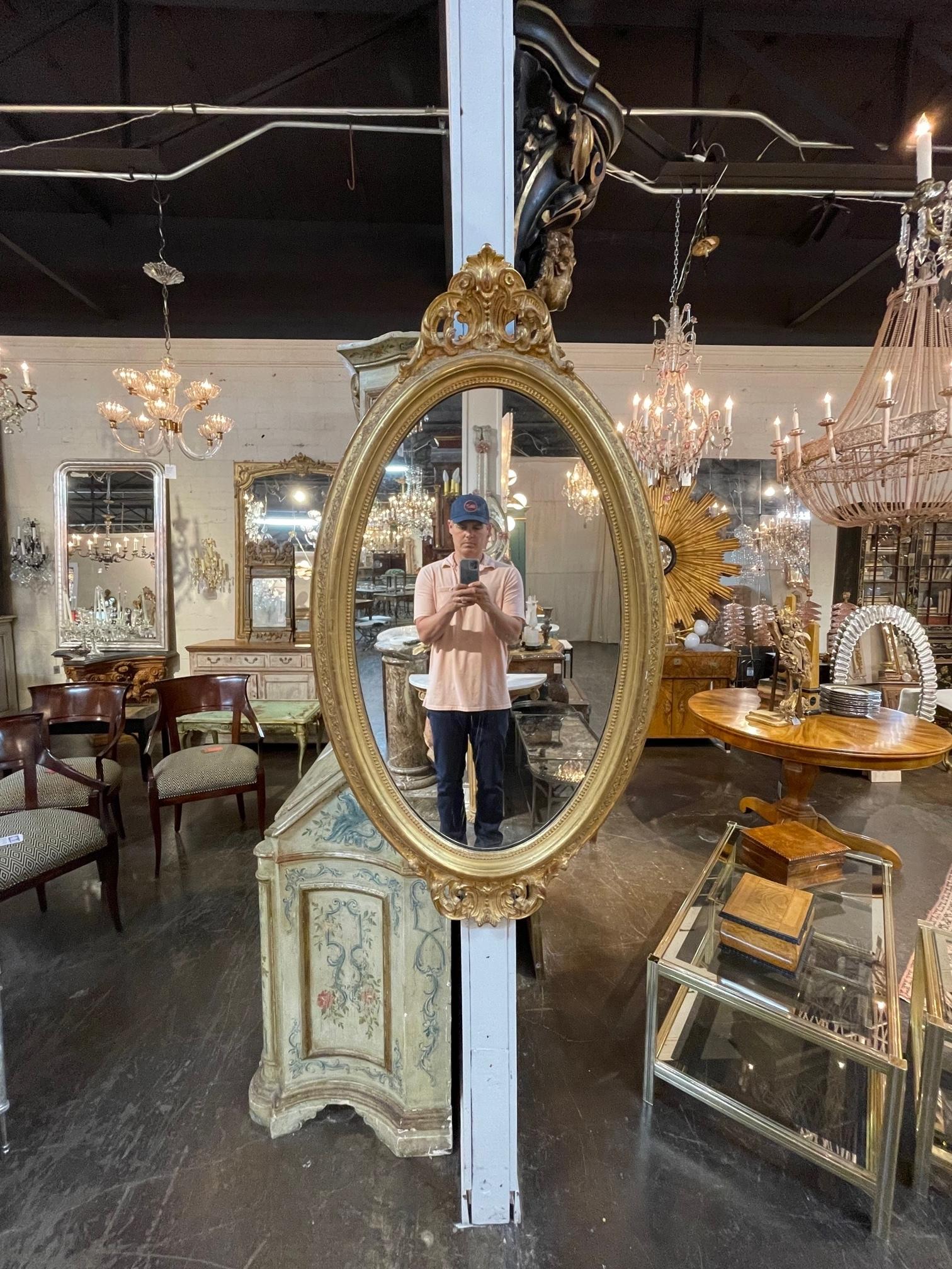 Exquis miroir ovale en bois sculpté et doré de style George III du 19e siècle. Il présente des sculptures très fines en haut et en bas du miroir. Ajoute une véritable touche d'élégance !