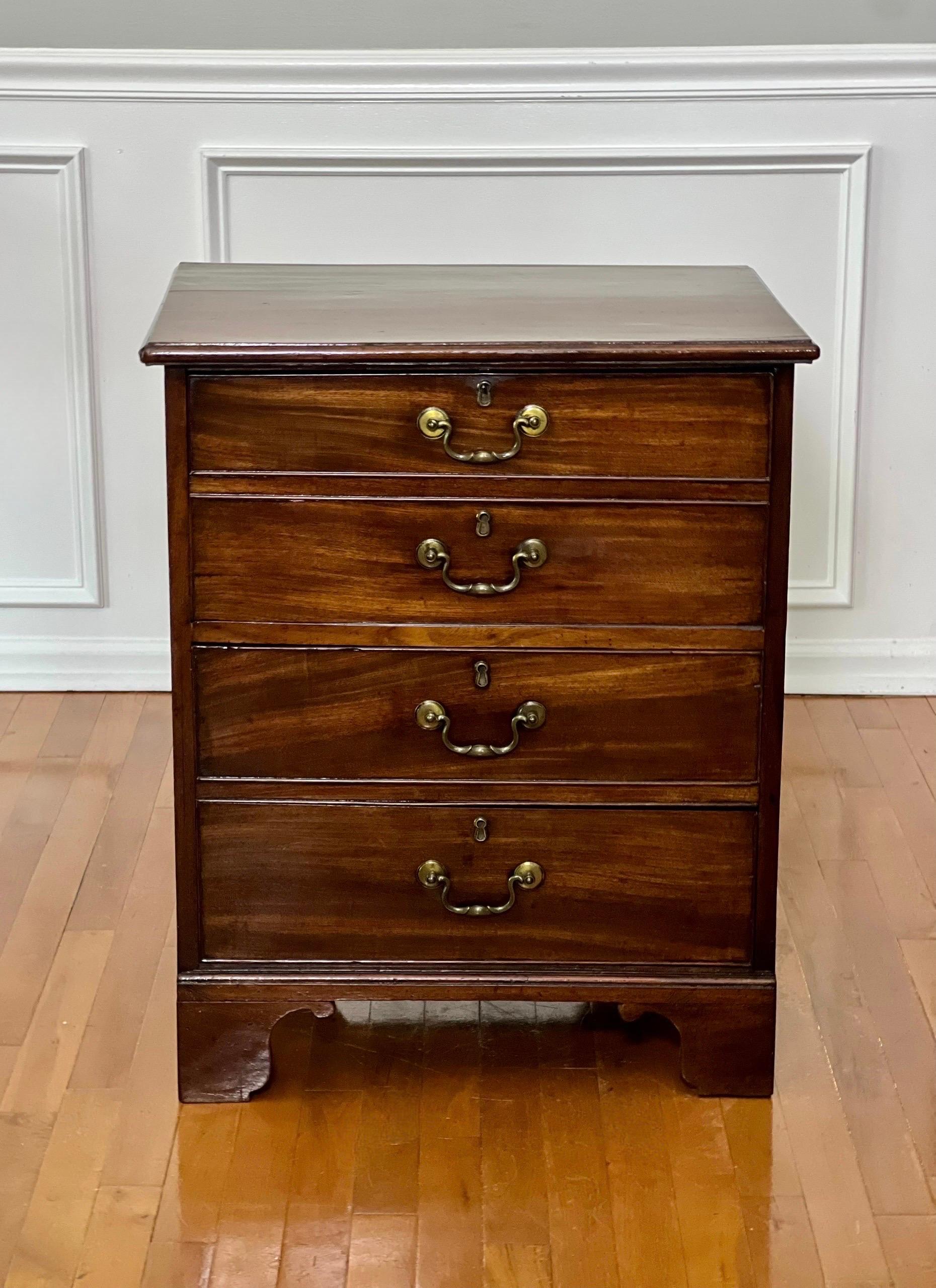 Well-proportioned 19th century English George III mahogany drop-front chest with two drawers. A classic piece with two faux drawer fronts which act as a drop-down door to reveal a spacious interior cabin. It unlocks with a vertically operated lever