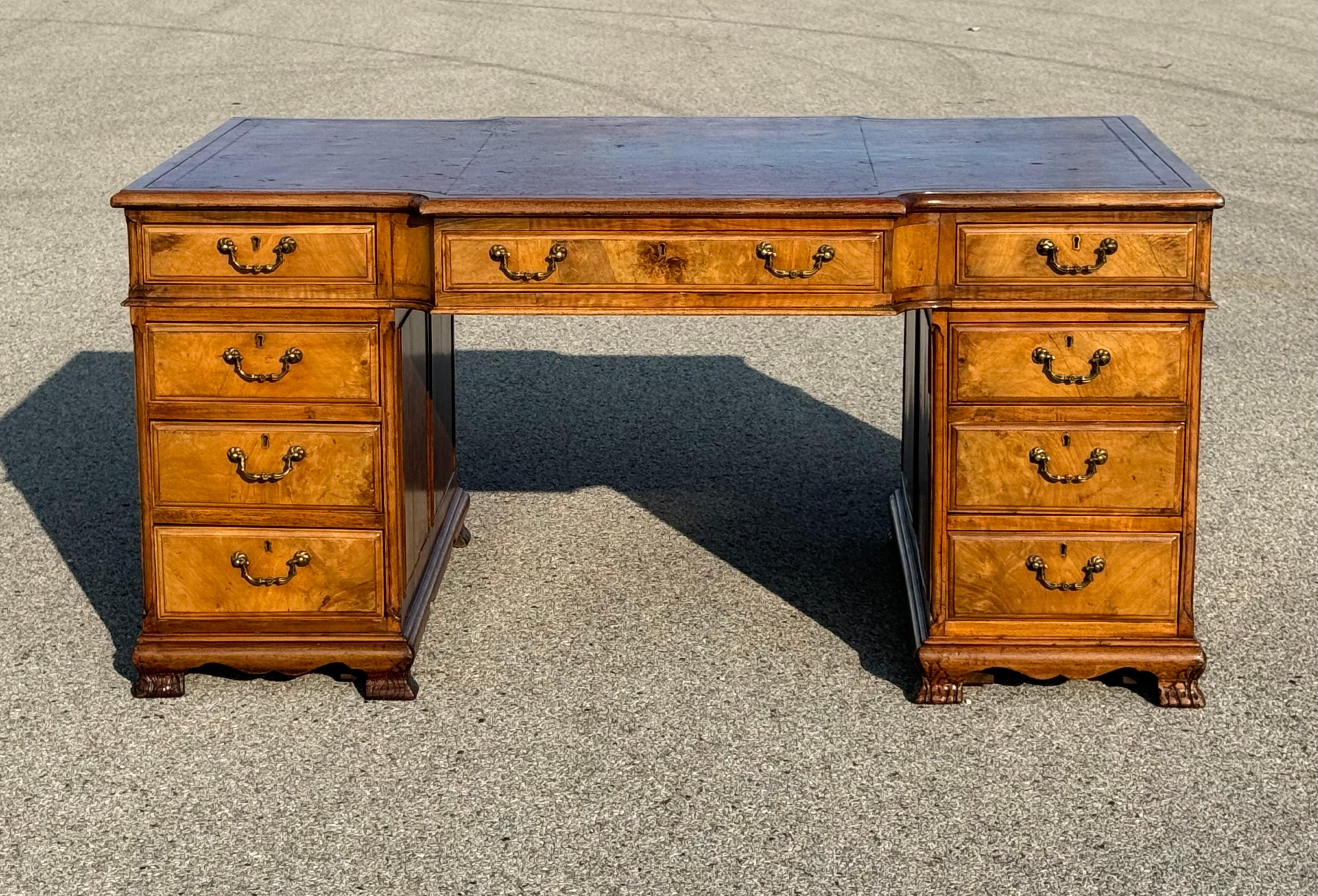 Un classico scrittoio inglese del XIX secolo, in stile Georgiano III, con un piano in pelle rossa originale con bordi lavorati, che mostra il carattere del tempo. La scrivania è dotata di nove cassetti sul lato direzionale e di ante sul lato