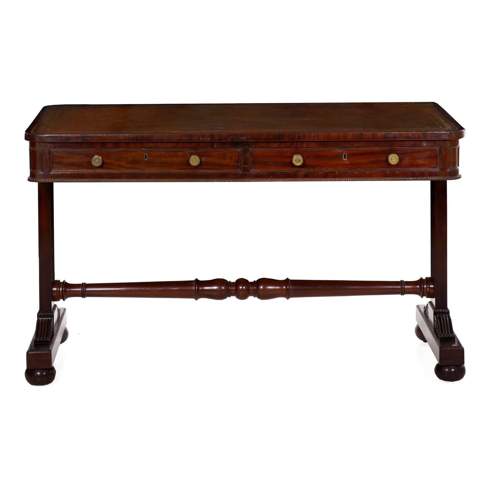 Of an attractive neoclassical form, this writing table is a product of the George IV period in England during the second quarter of the 19th century. Utilizing vibrant mahogany veneers around the top of the desk, the highlight is this beautiful