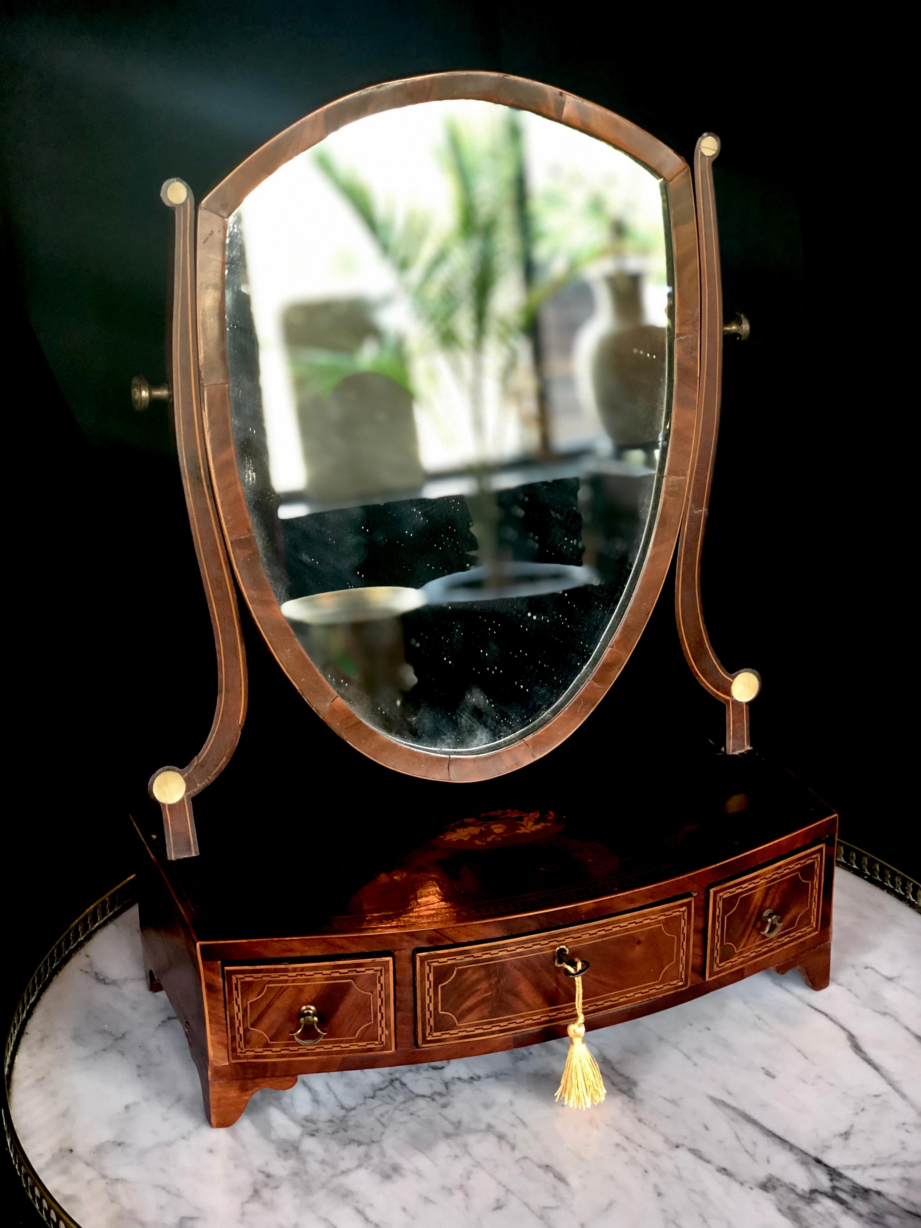 Gorgeous mahogany frame. The surface has been inlayed with oak leaves and acorns in a center medallion. The perimeter is outlined with banded inlays. Three fitted drawers are also outlined with string inlay patterns. One working key.