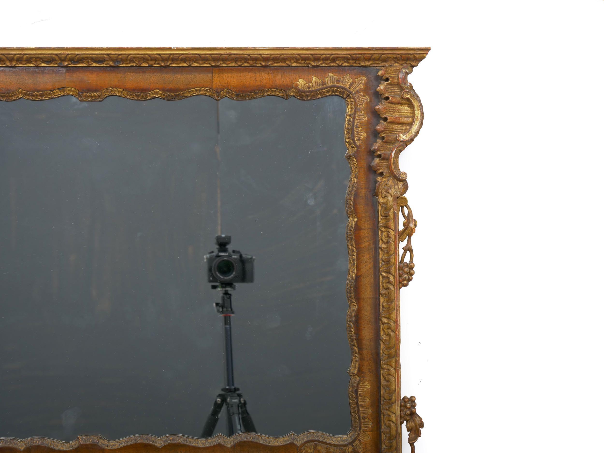 A gorgeous wall mirror from the mid-19th century, this originally housed a painting in the upper portion and the mirror in the lower portion. The painting has since been replaced with a modern piece of mirrored glass. It is crafted out of burlwood