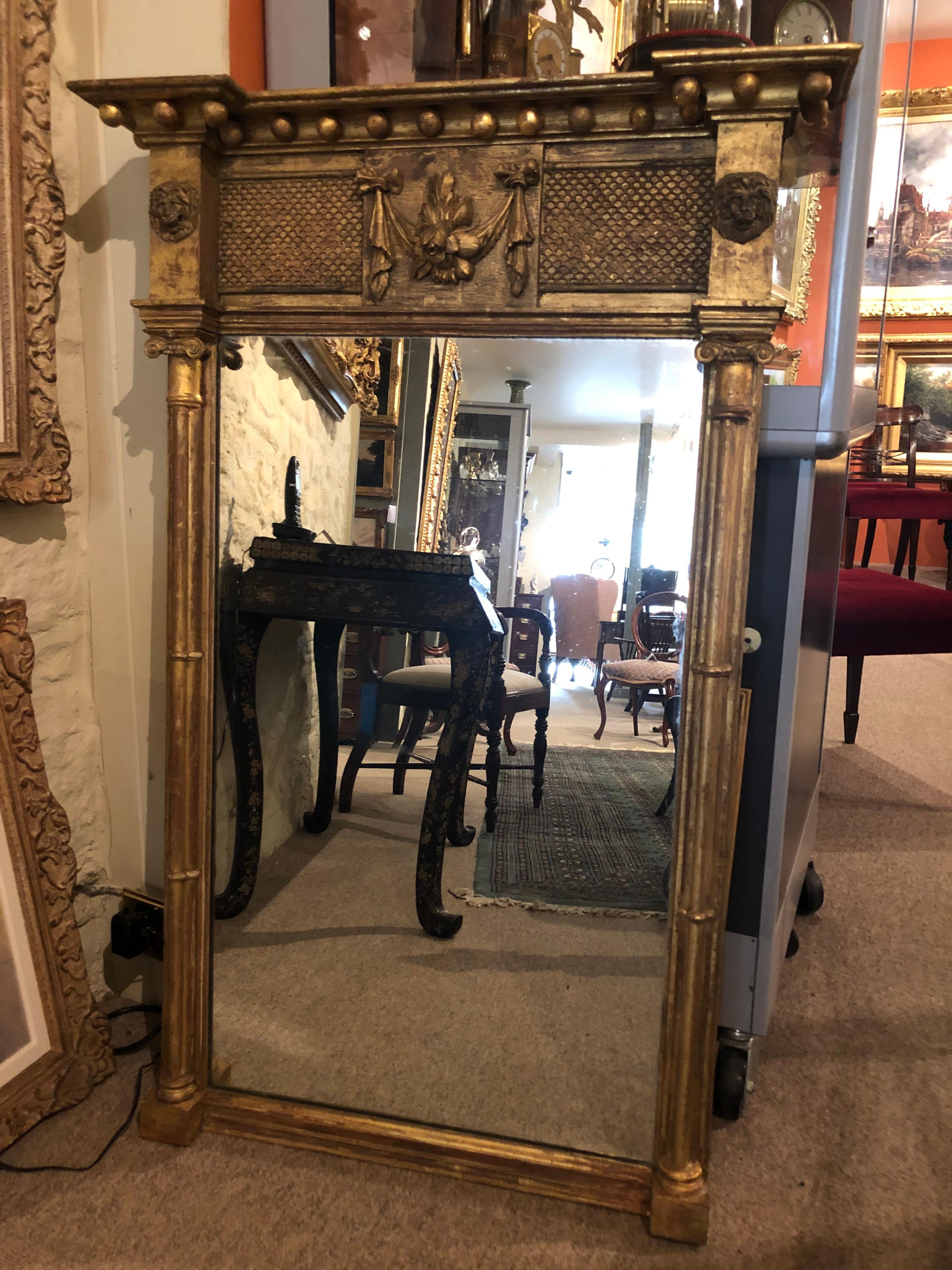 A good 19th century English gilt rectangular pier mirror flanked by columns either side of the mirror below lion head masks surmounted by decorative central frieze and ball shot cornice. The replaced mirror plate is in good condition.