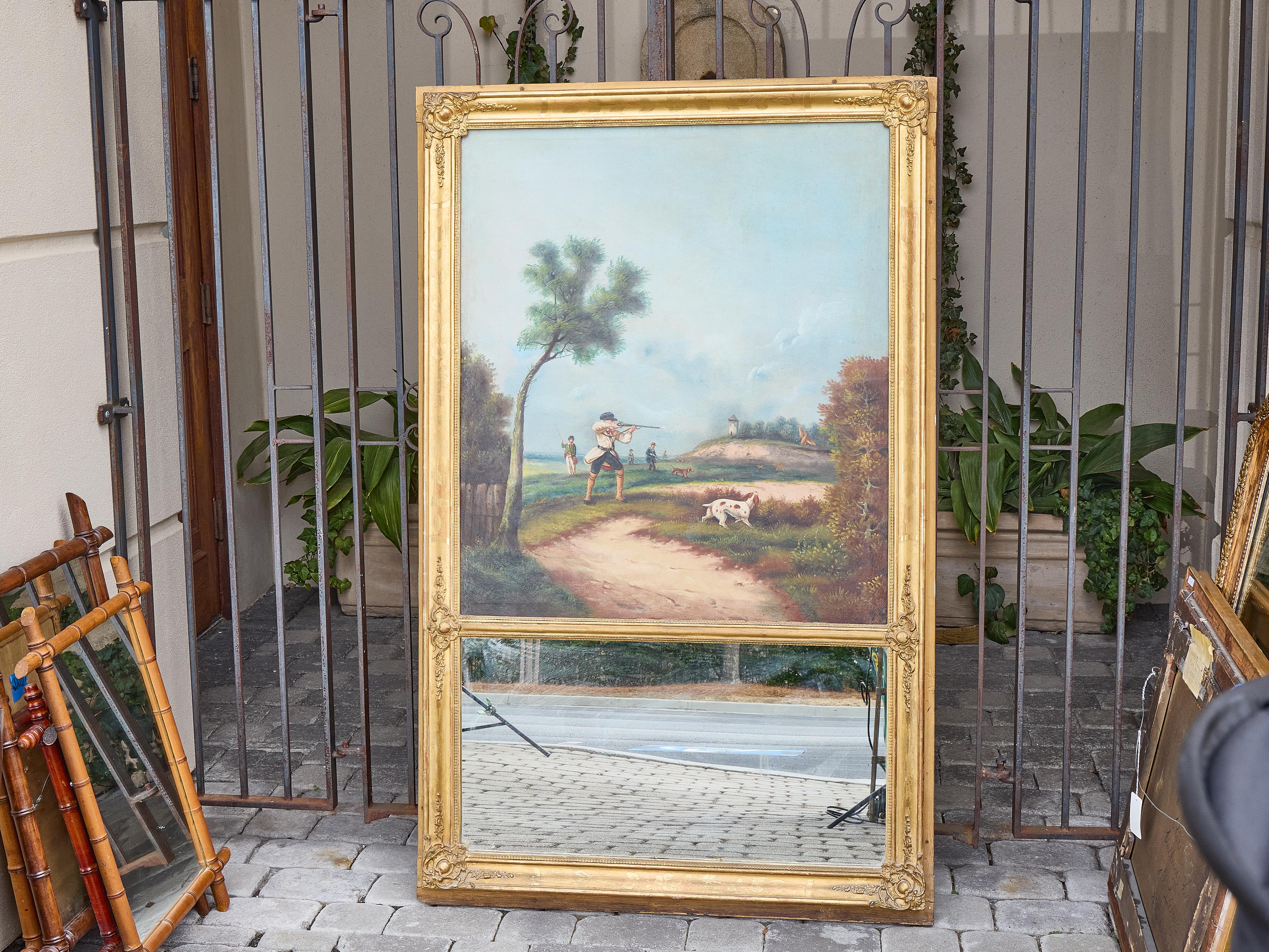 Questo alto specchio trumeau inglese combina il fascino narrativo di una scena di caccia in campagna del XIX secolo con l'eleganza architettonica della cornice in legno dorato. Dipinto a olio su tela, il registro superiore raffigura un vivace