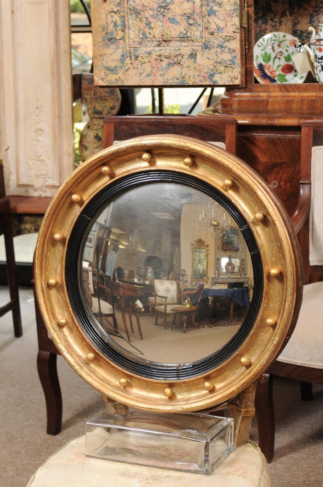 Regency style giltwood Bullseye mirror with convex glass ebonized detail and gilt orbs around the perimeter, England, 19th century.