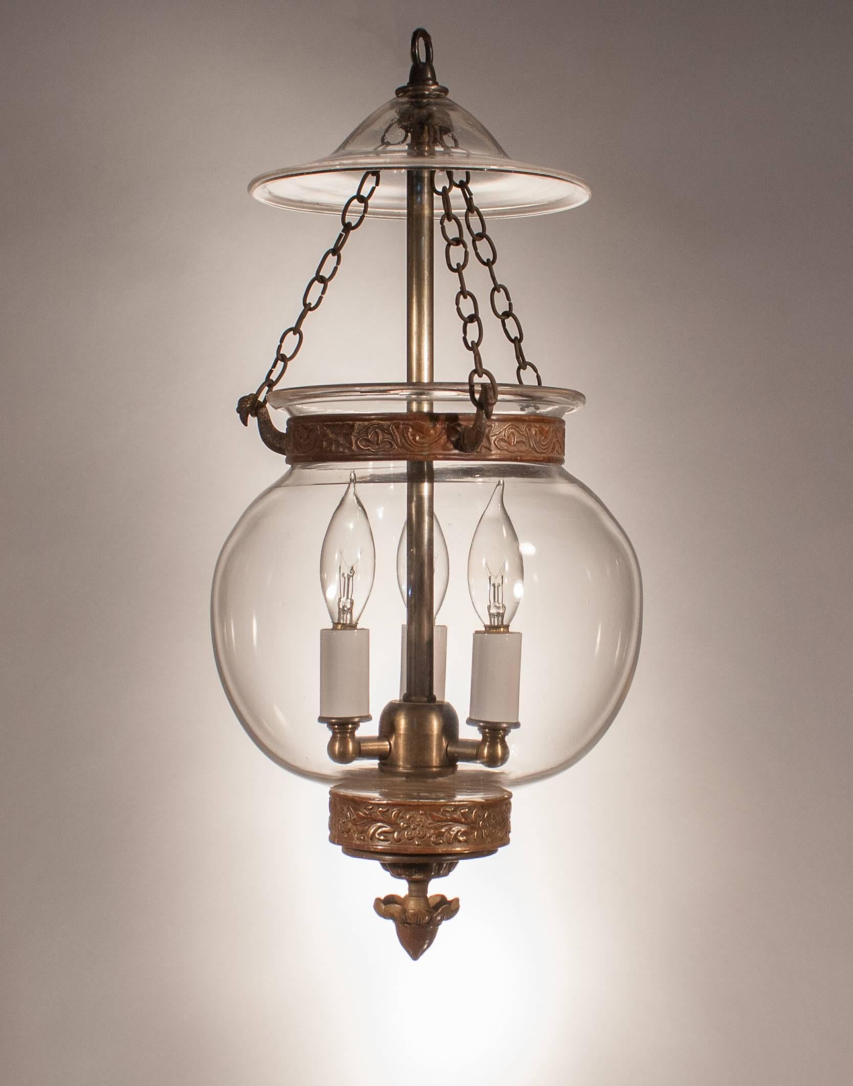 A Stand-out lantern in our bell jar lighting collection, this circa 1890 globe pendant features excellent quality handblown glass and a lovely silhouette. In addition, the ornate finial and brass band (not original to the lantern) are the perfect