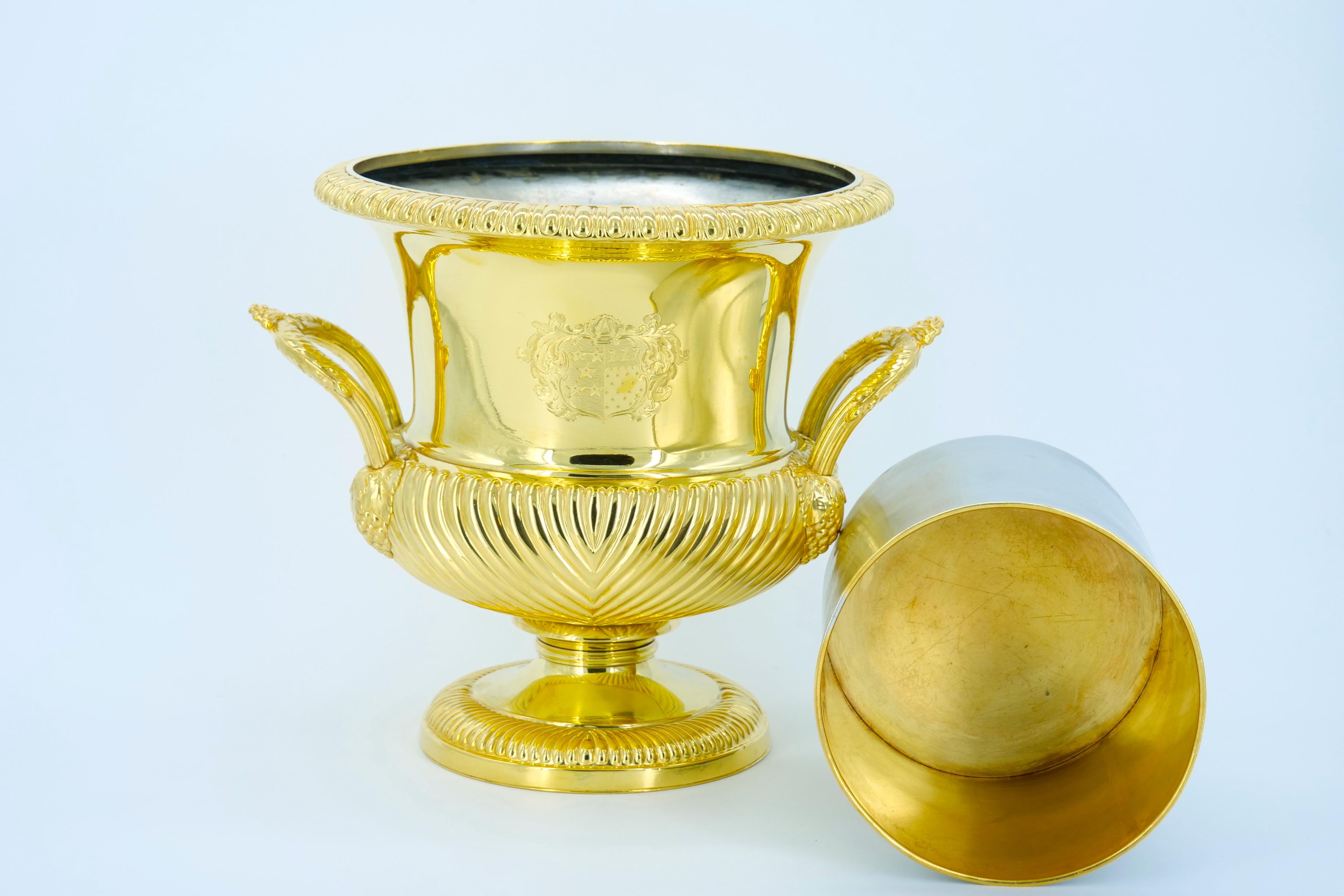 English Victorian period campana vase form gold-washed silverplate ice bucket with foliate handles, gadrooning at the base and waist with rim decorated with egg-and-dart motif. With original two-piece liner. Inscribed rampant dragon engraved on one