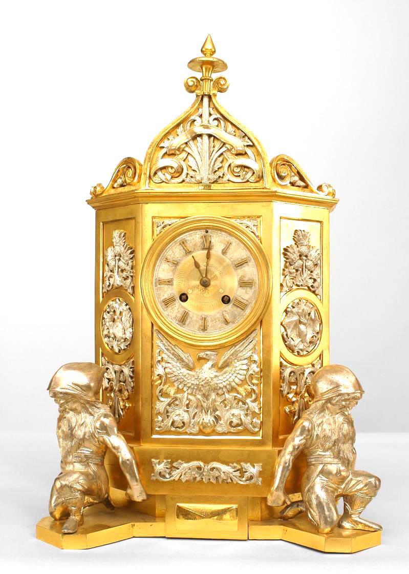 English Gothic Revival style (19th Cent) gilt mantle clock with silver plate decoration and supported by 2 gnome figures with a pediment having a finial top. *Not working
