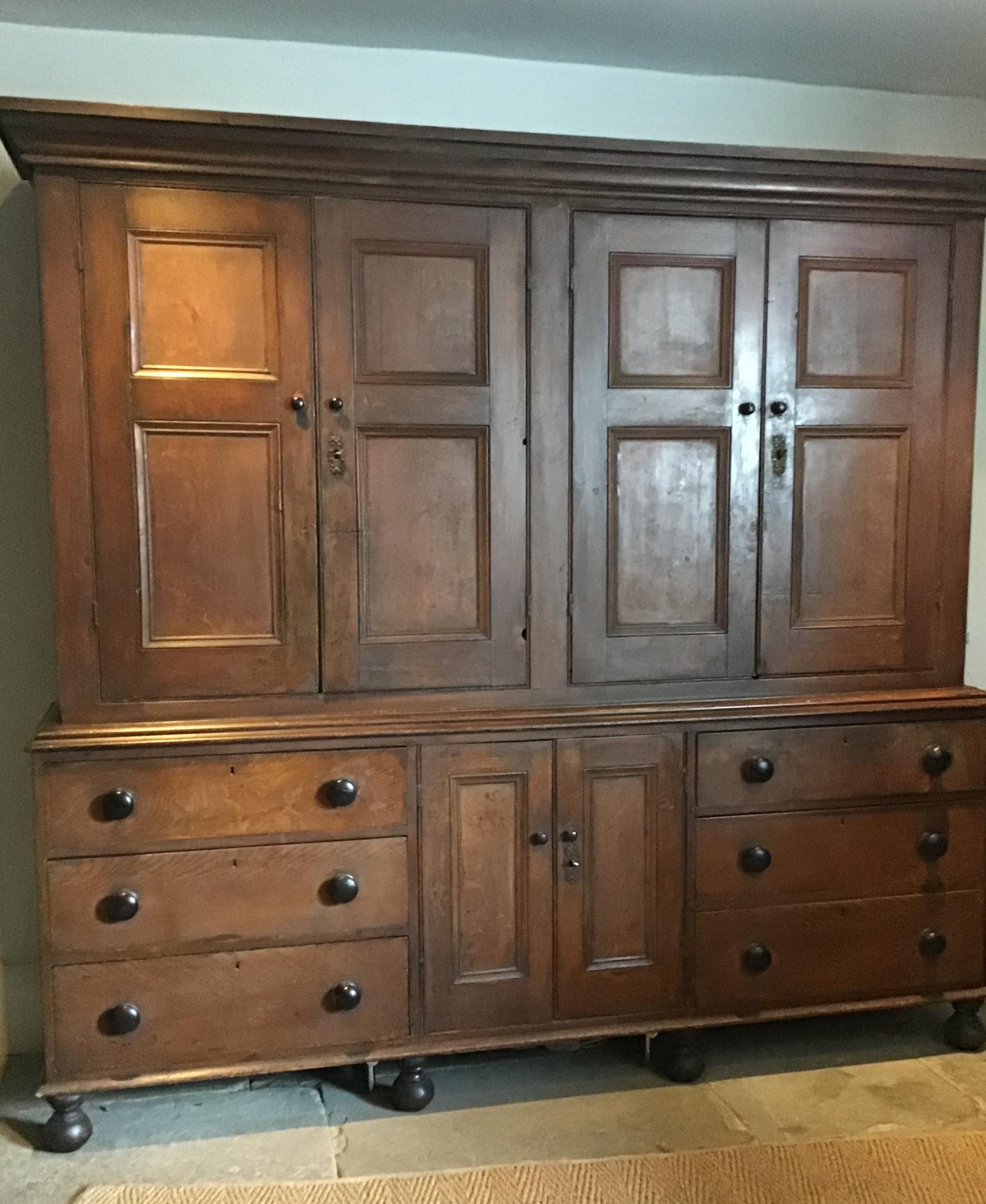 Mid-19th century English oak scumbled pine having four panelled doors enclosing shelves above two smaller panelled doors flanked by six short drawers
This piece, probably from the County of Shropshire England retains its original surface of wood