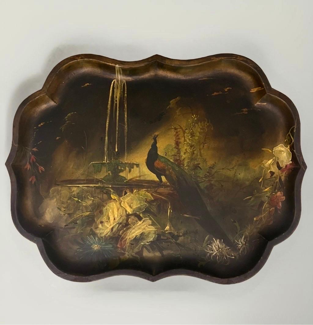 Bandeja tole de la época victoriana pintada a mano con pavo real y flores en estilo chinoiserie, Inglaterra, mediados del siglo XIX.  Un destacado pavo real ocupa el centro de esta cautivadora escena y está rodeado por una fuente en cascada, flores