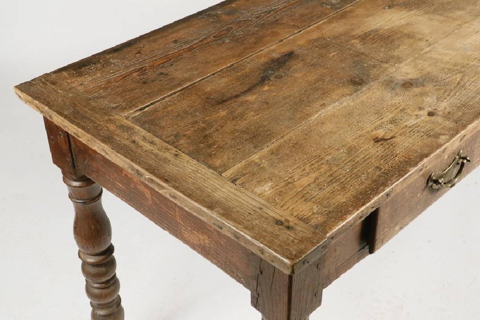 19th century English (possibly Irish) pine and oak long hall or farm table; three plank top with breadboard ends, four drawers (one side) with bronze pulls, bulbous ring and urn turned legs.


Dimensions: 28
