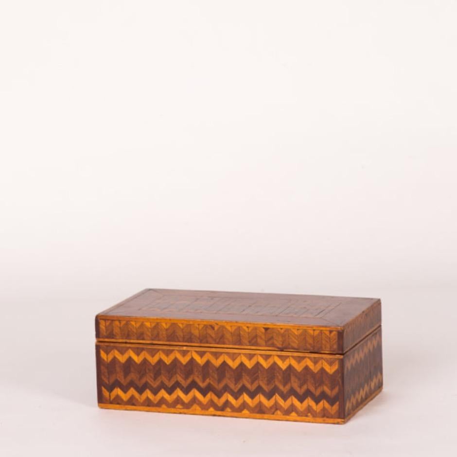 Late 19th-century English inlaid box featuring a gradient zig-zag pattern in rich honey tones. The bargello-like exterior makes a wonderful contrast with the aquamarine velvet lined interior. Energetic yet subdued, the box would be an elegant way to