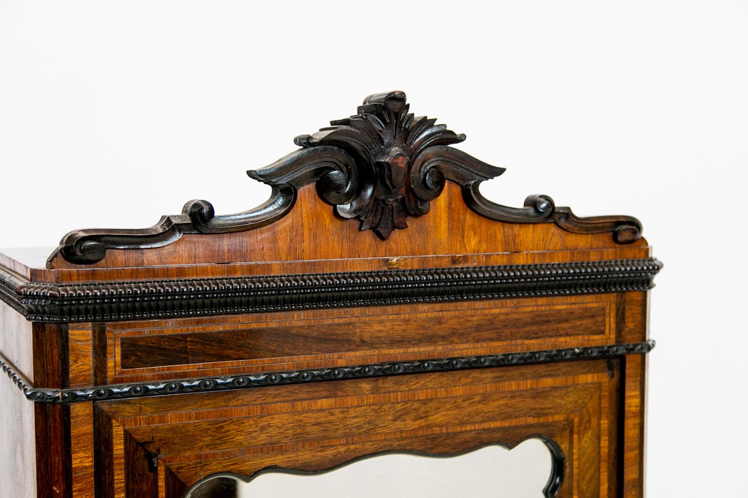 19th Century English inlaid miniature armoire cabinet, with walnut crossbanding and rosewood veneer. It has a single drawer with puzzle inlay. Other features are beaded base molding, carved crest, and mirrored door.
   