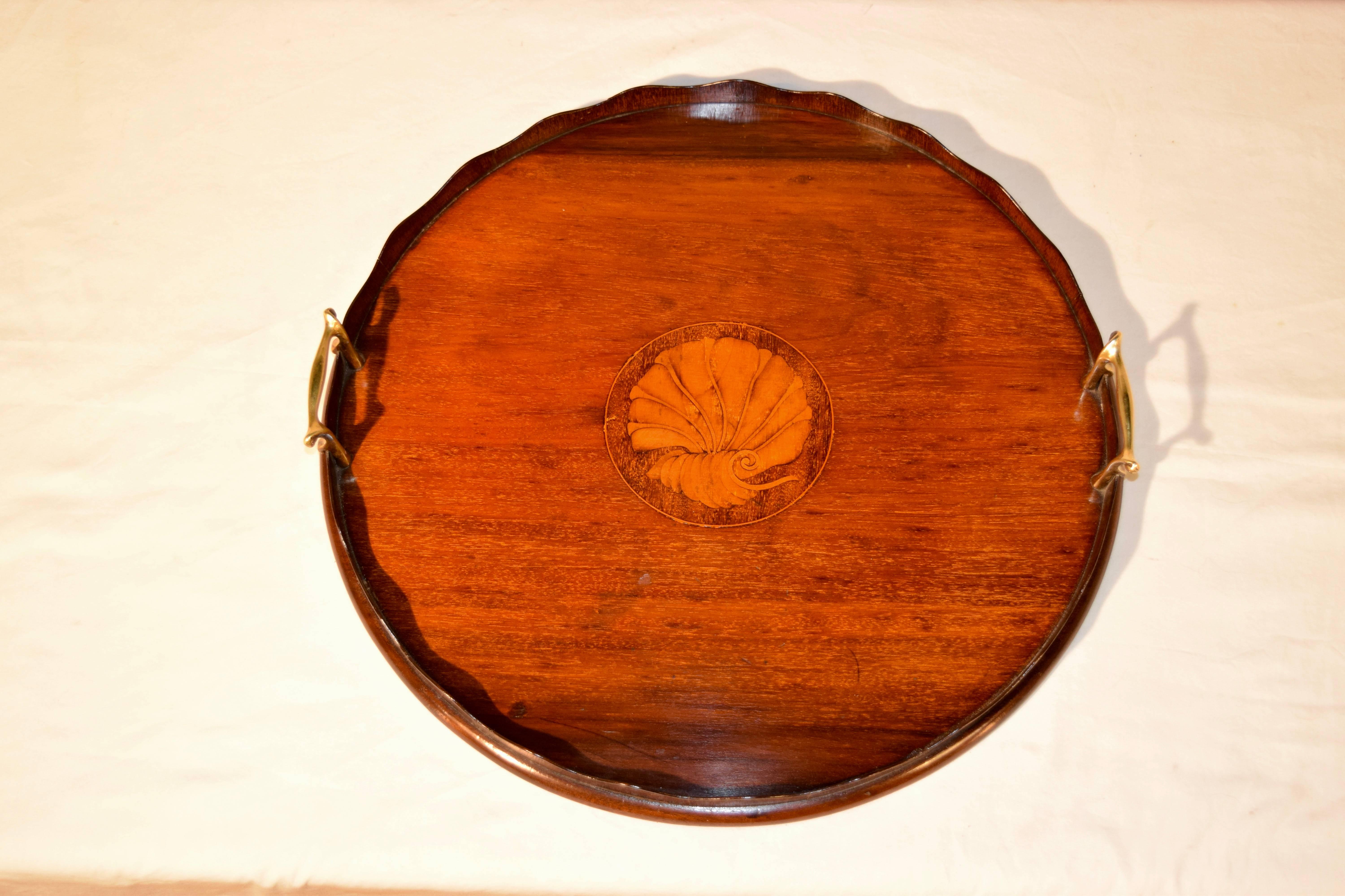 19th century English tray with a scalloped gallery and brass handles made from mahogany with a central medallion which has an inlaid shell decoration in satinwood.