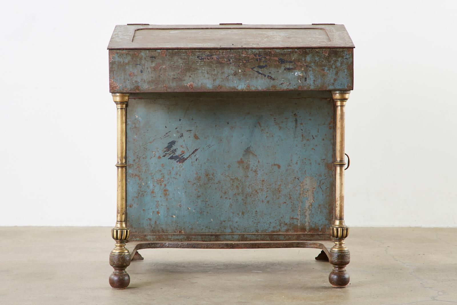 Rare 19th century English Industrial period davenport desk. Made from thick iron with bronze legs and campaign style handles on the drawers. The locking slant lid opens to reveal a large storage area with pigeon holes and two storage drawers. The