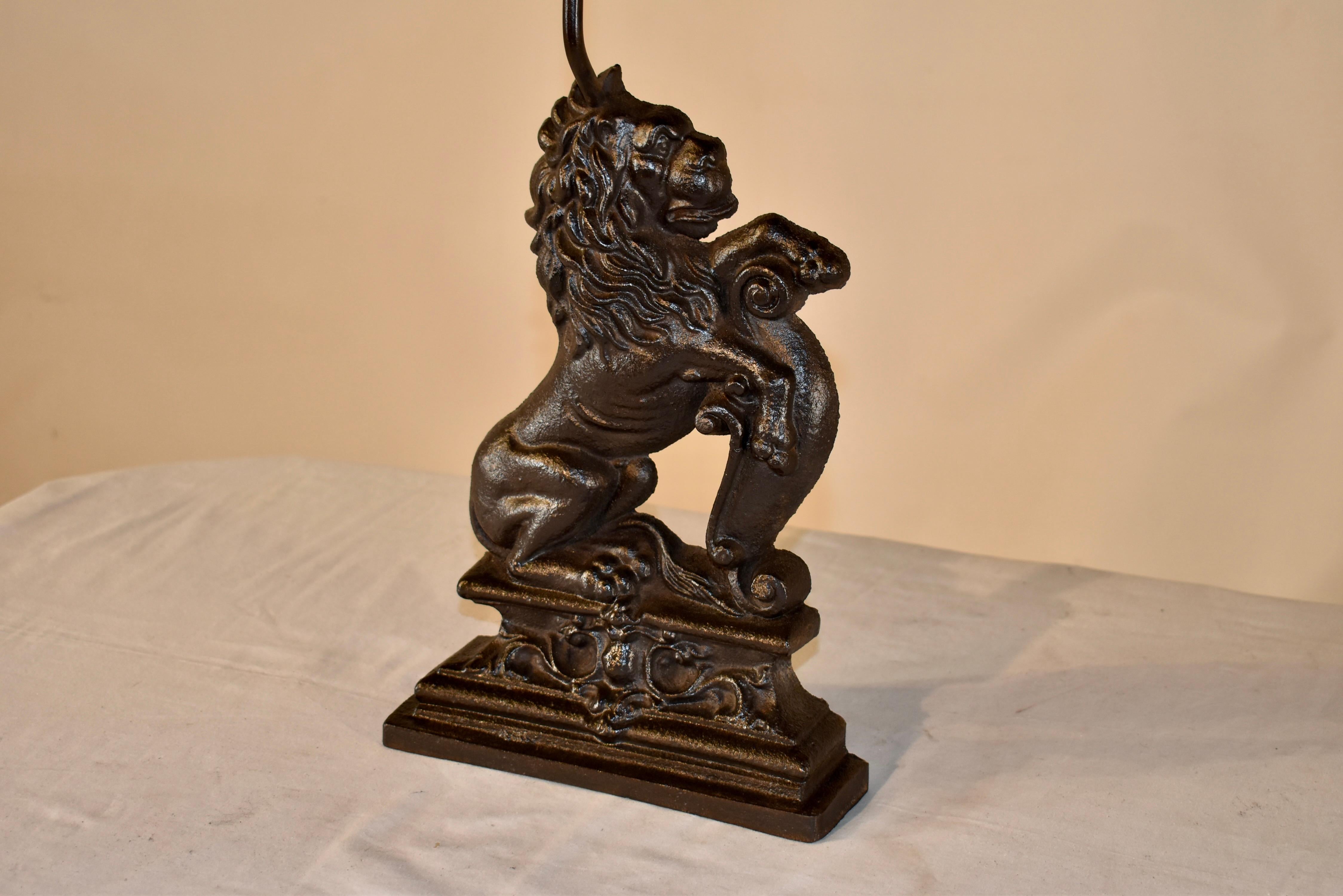 19th century English doorstop cast from iron.  The handle on the top makes it easily moveable.  the doorstop is in the form of a lion with his paw resting on top of a scroll.  the molded base is lovely and has great detail.  