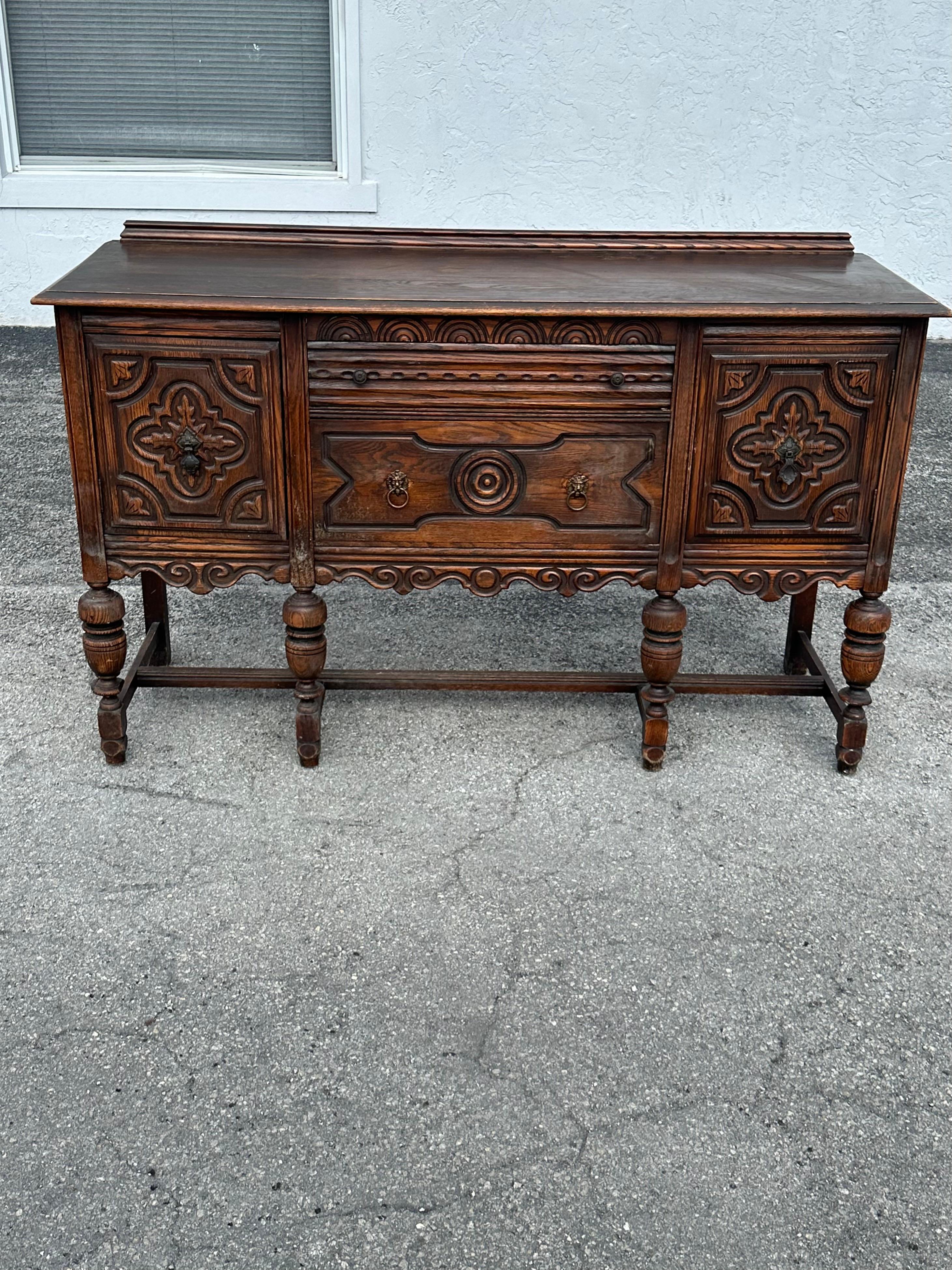 L'antica credenza in legno intagliato di origine giacobina è un magnifico mix di fascino storico e funzionalità. Realizzato in legno di alta qualità, presenta i caratteristici intagli ornamentali dell'epoca e una struttura robusta. I motivi floreali