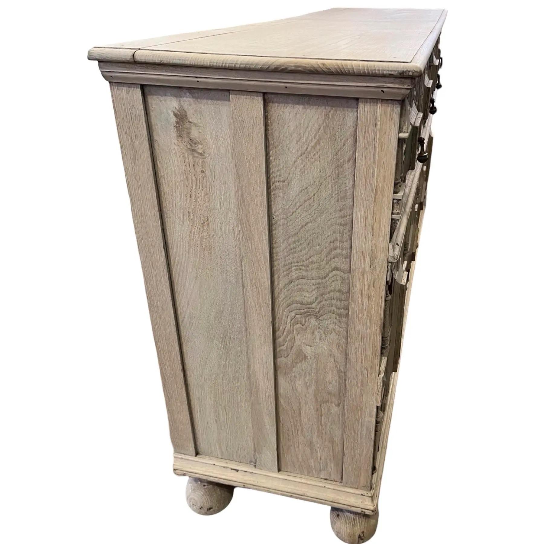 Jacobean style sideboard hand-made in the late 1800s using oak. The sideboard shows a four over four layout with four drawers over fours doors. Each door and drawer shows the geometric molding that is typical of the Jacobean style.  On the insides,