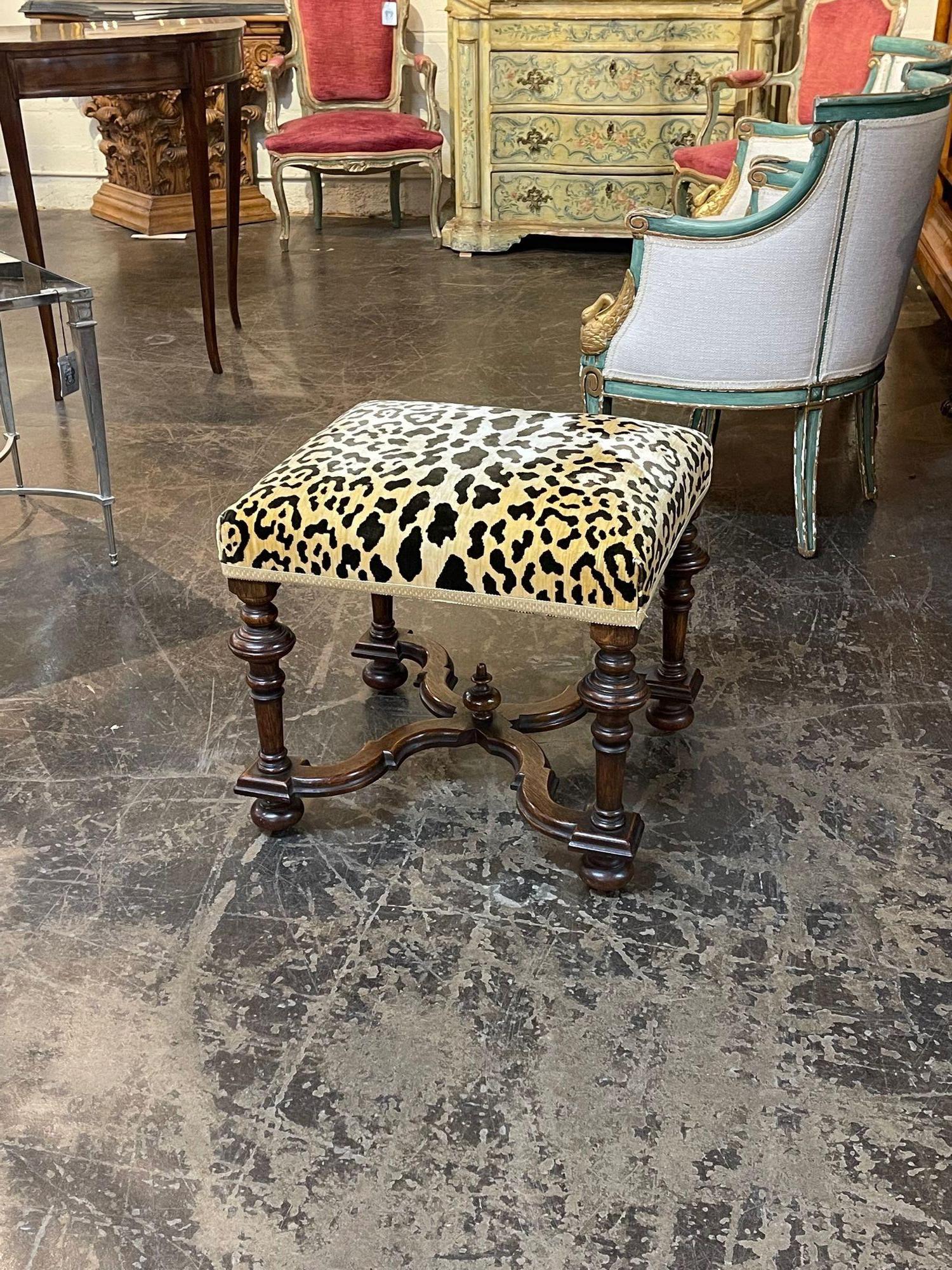 Gorgeous 19th century English Jocobean style walnut stool. Featuring nice carved legs and upholstered in a lovely cheetah fabric. A great accessory!
