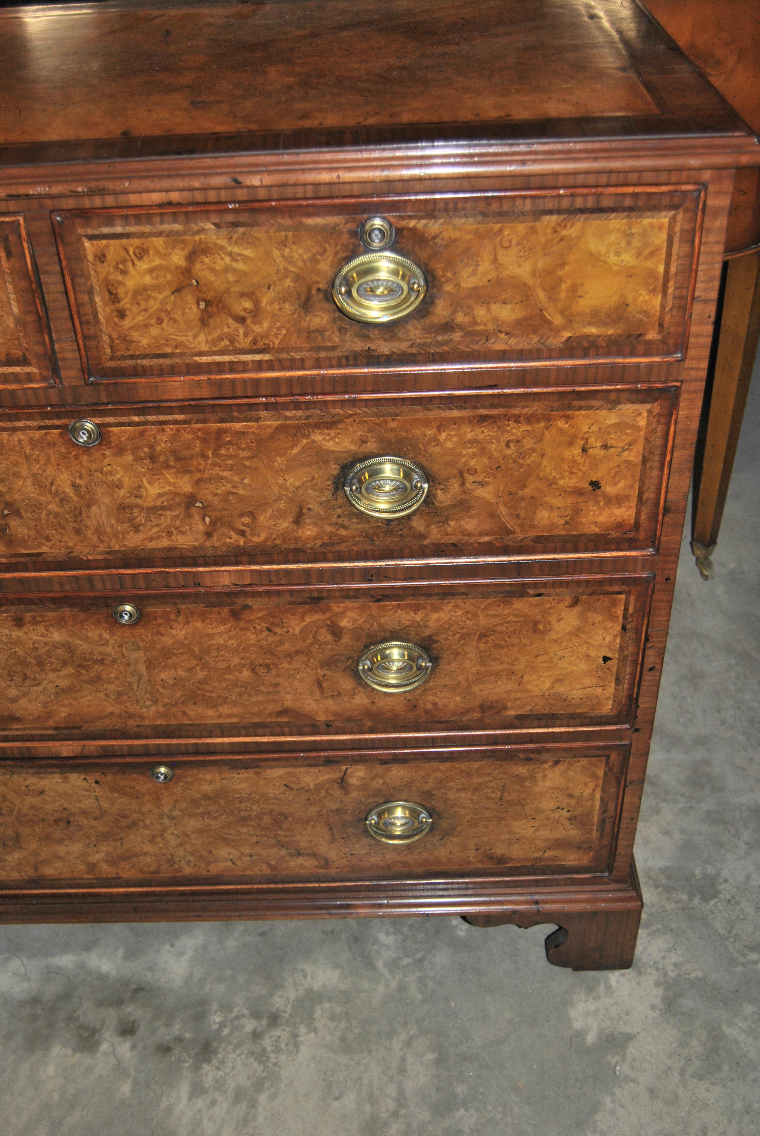 This is a chest of drawers, dresser made in England, circa 1820. The top has a nicely molded edge with a Herringbone walnut inlay and Kashmir walnut to the centre of the top (Kashmir Walnut is the finest cut of Burr Walnut). There are 2 shorter