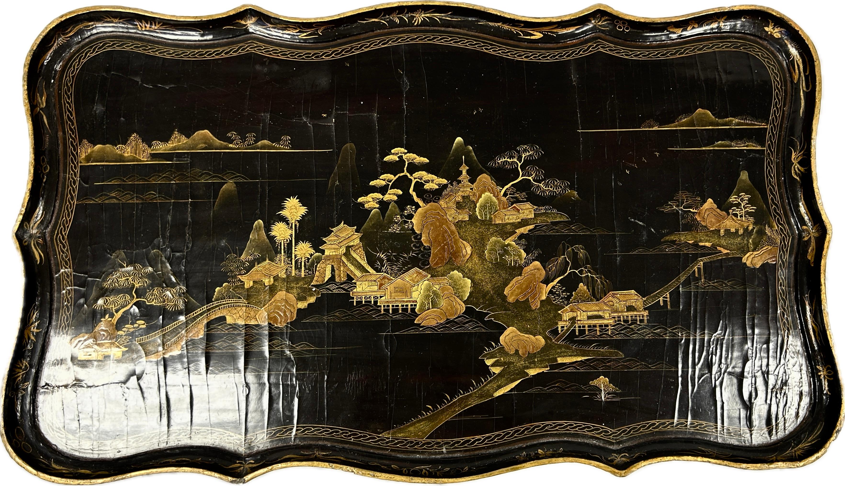 19th Century English Chinoiserie lacquered table. Table has one drawer. Hand-painted Chinese landscape in rich colors of gold, mossy green, and brown on a black background. Curved legs are are black lacquered wood culminating into gold embellished