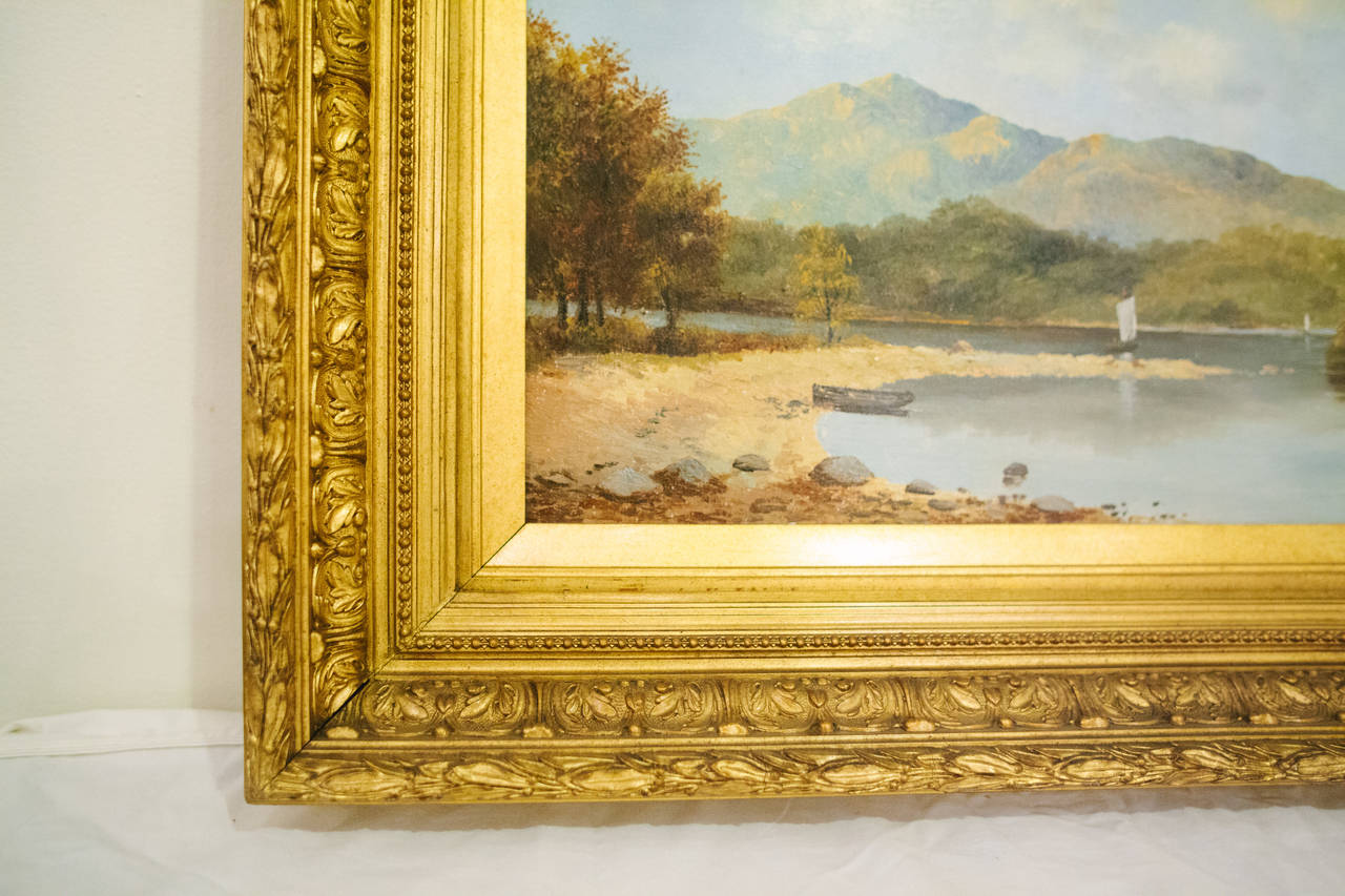 This English landscape on canvas, circa 1880, features one sailboat in the foreground along with a small row boat. You can also view a sailboat in the background. It is in its original giltwood frame.