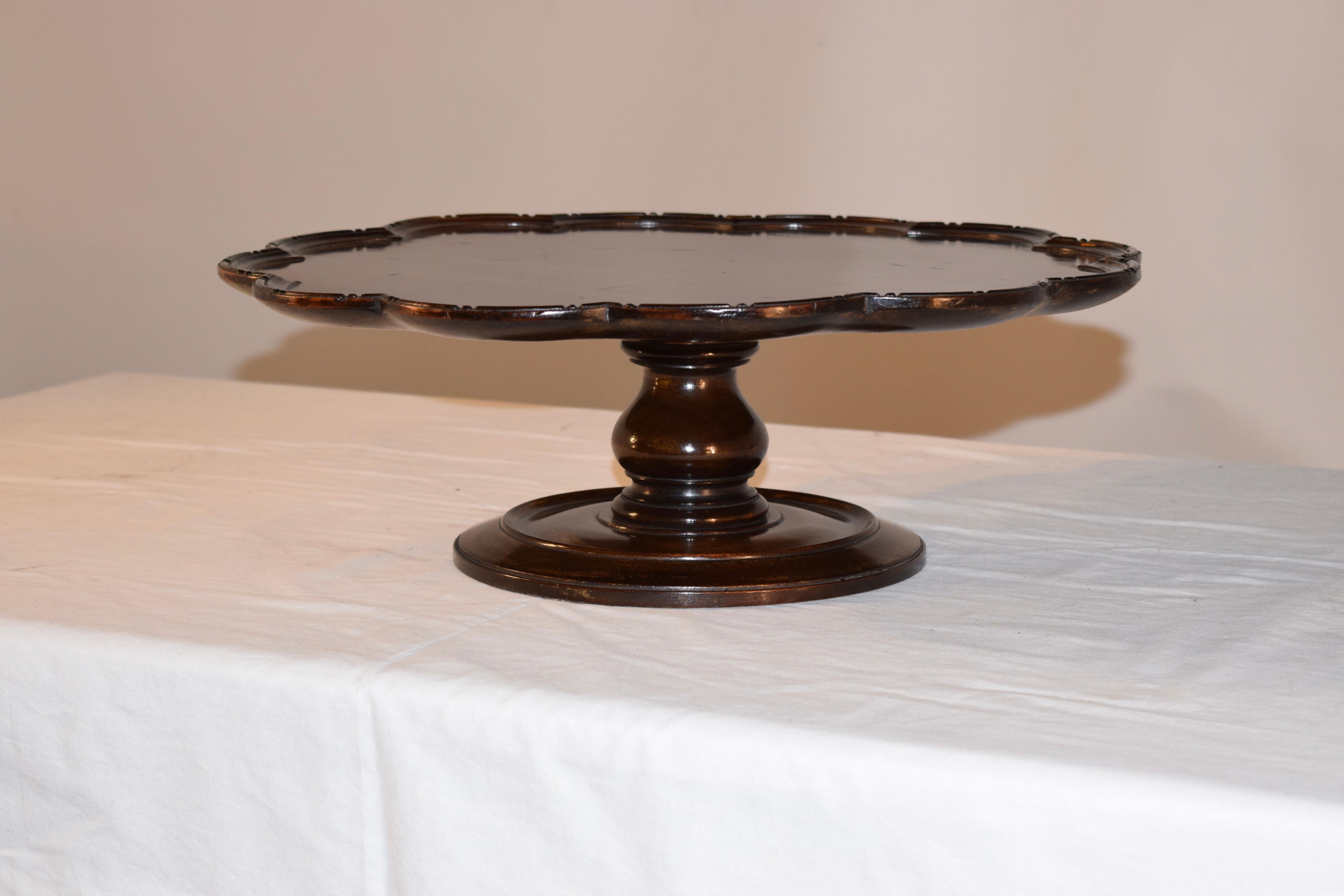 19th century Lazy Susan from England made from mahogany. The top is wonderfully scalloped and hand carved decorated around the edge, following down to a nicely hand-turned column and supported on a hand-turned base.