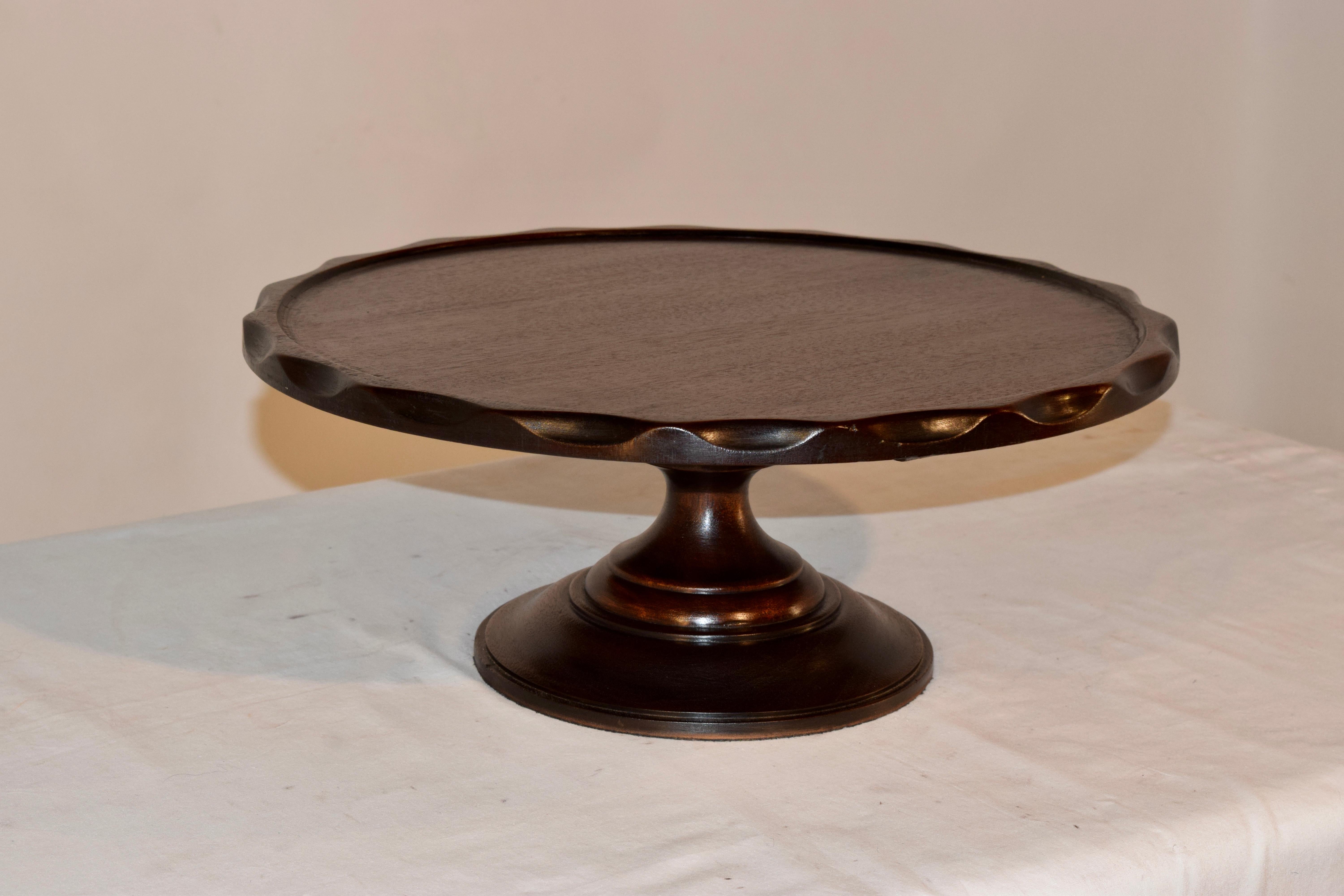 19th century English lazy susan made from mahogany. The top has a molded edge and is slightly raised following down to a hand-turned base.