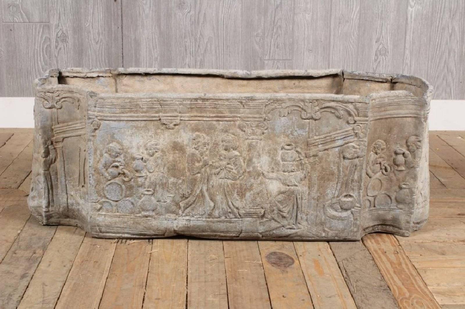 Beautiful shaped lead planter has figural detail on all sides of classical relief depicting daily village life. Generous size and gorgeous presence.