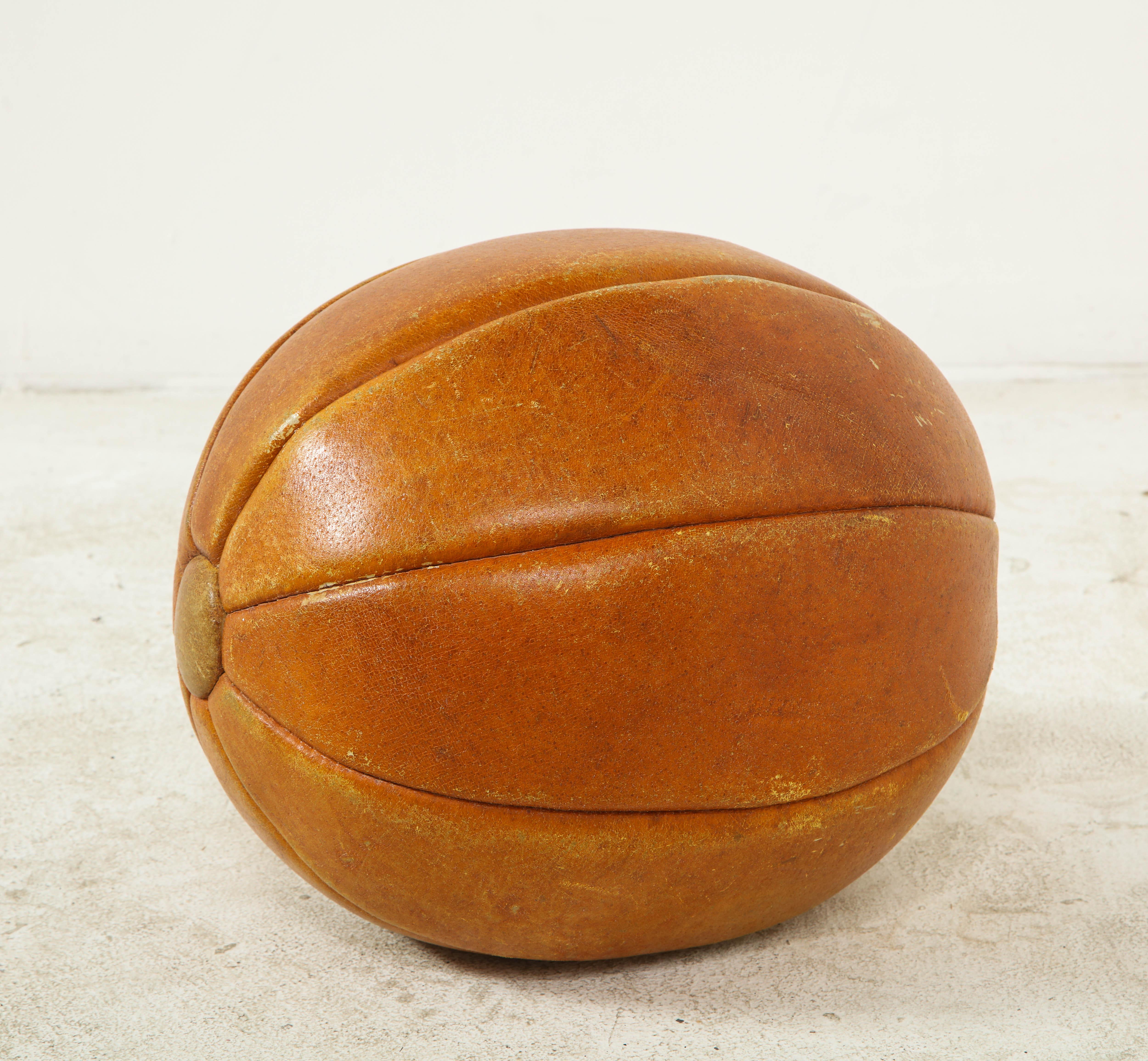 Early 20th century English leather ball. Slightly elongated with button ends.