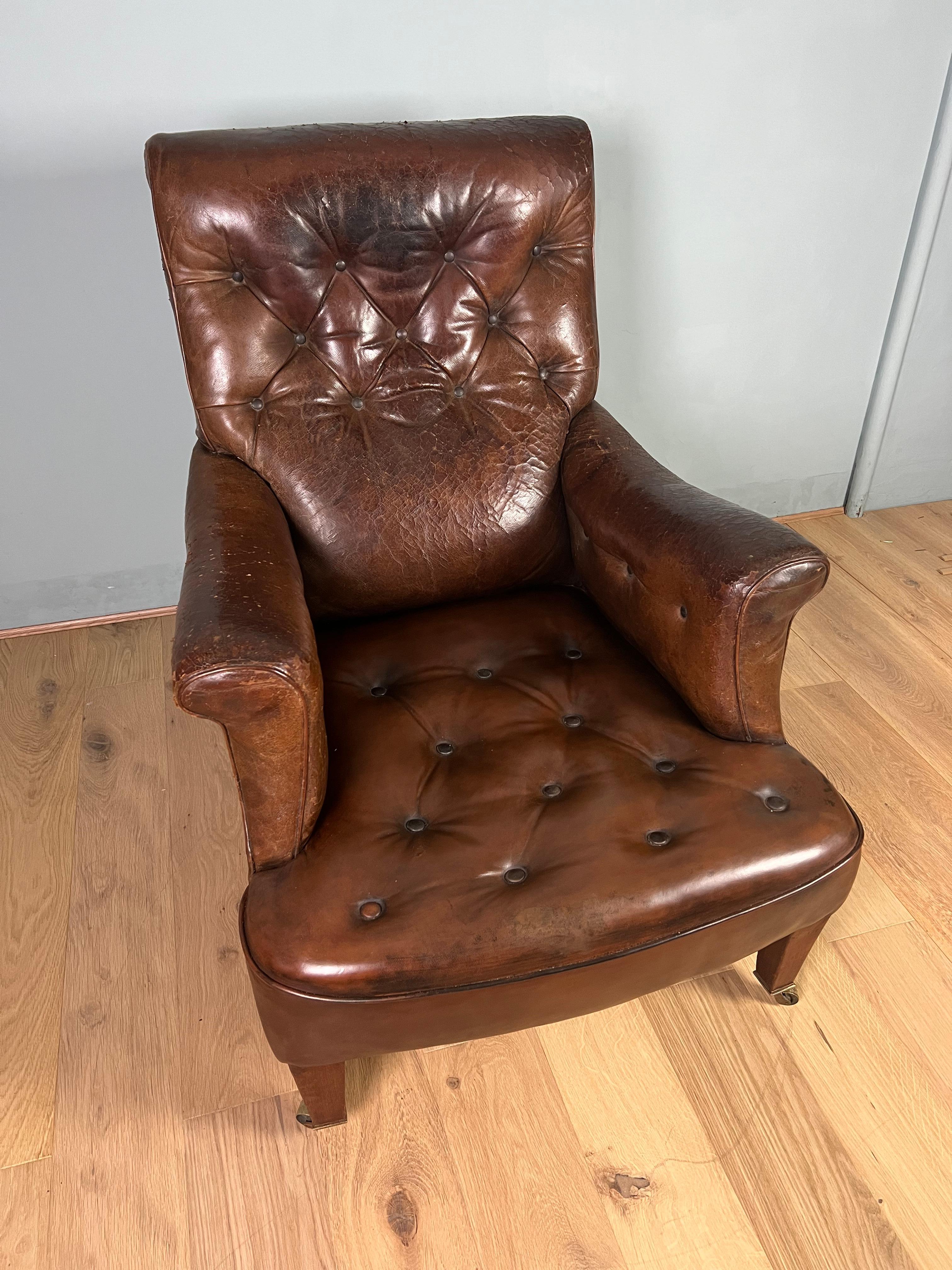 An attractive and extremely comfortable Victorian leather, deep buttoned, “Howard” style, country house easy armchair. This lovely shaped armchair has very elegant square tapered legs with brass casters. The leather to the back and arms has a nice