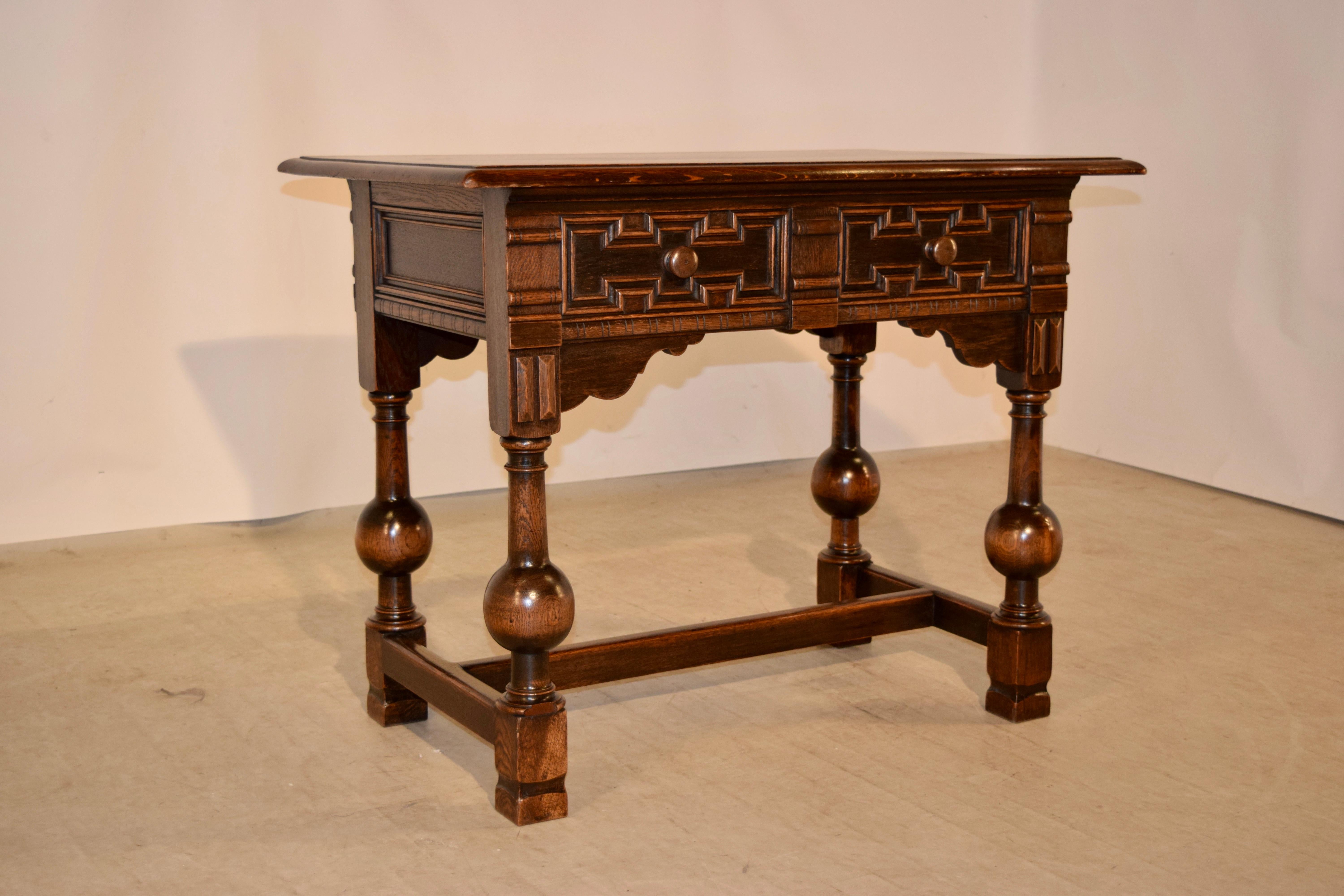 Late 19th century English oak library table with bevelled edge around the top. The piece has two drawers on one side and two matching false drawers on the other side for easy placement in any room. It is supported on wonderfully bulbous legs,