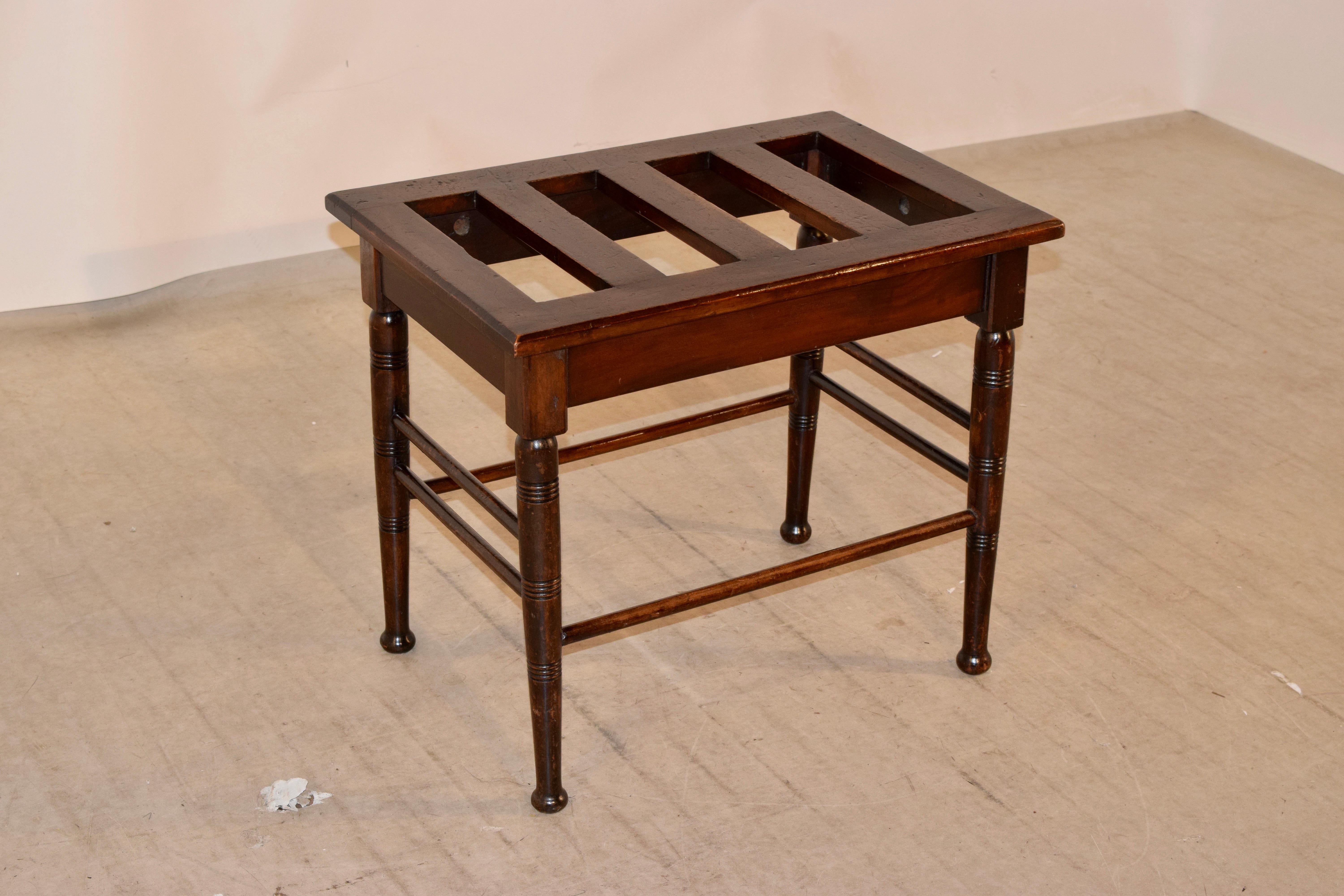 19th century English luggage stand made from mahogany. The top is slatted and has a nice overhang, the base has hand turned legs, which have routed decoration, and are joined by simple turned stretchers.