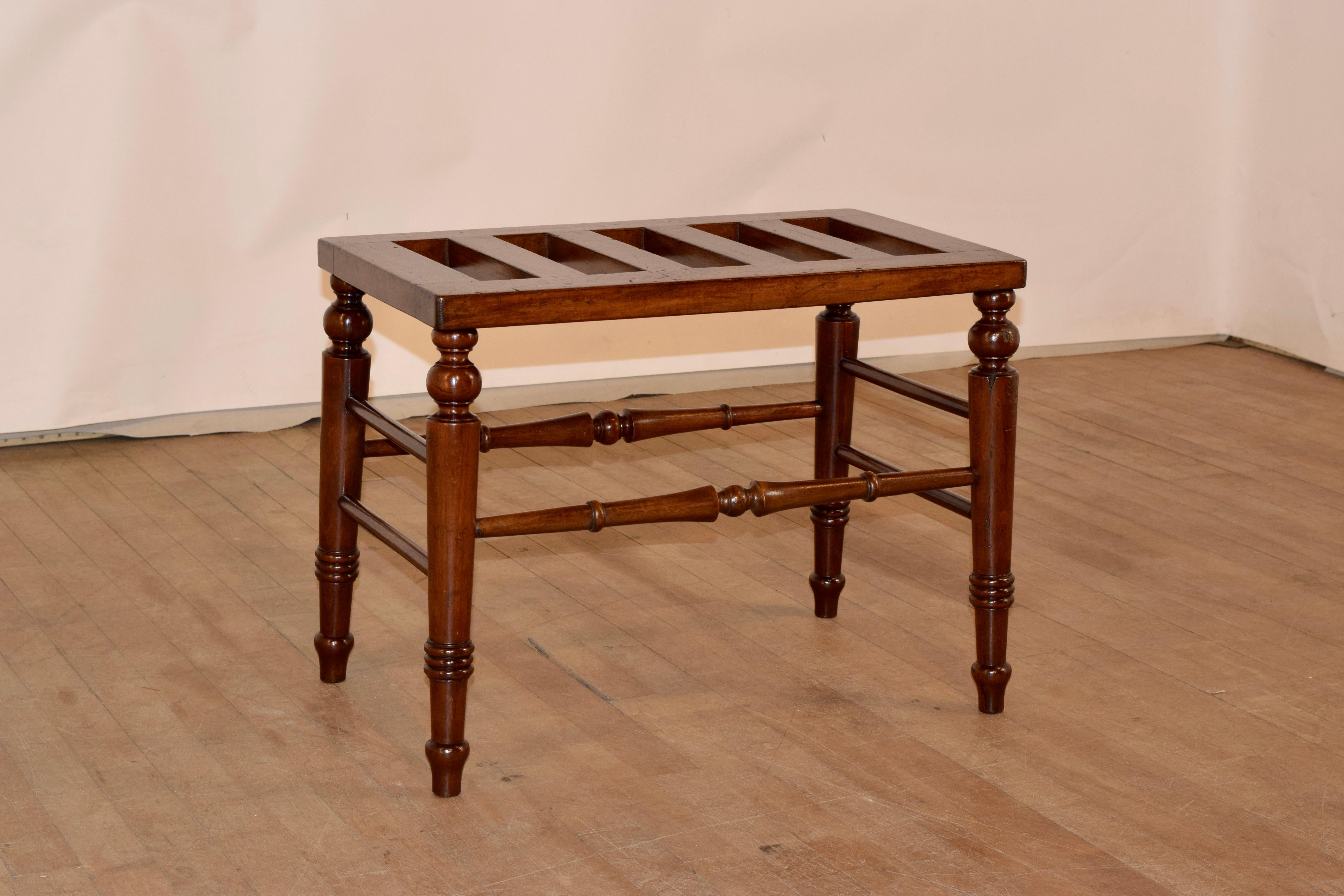 19th century mahogany luggage stand from England with a slatted top over hand turned and spayed legs, joined by lovely detailed stretchers.  