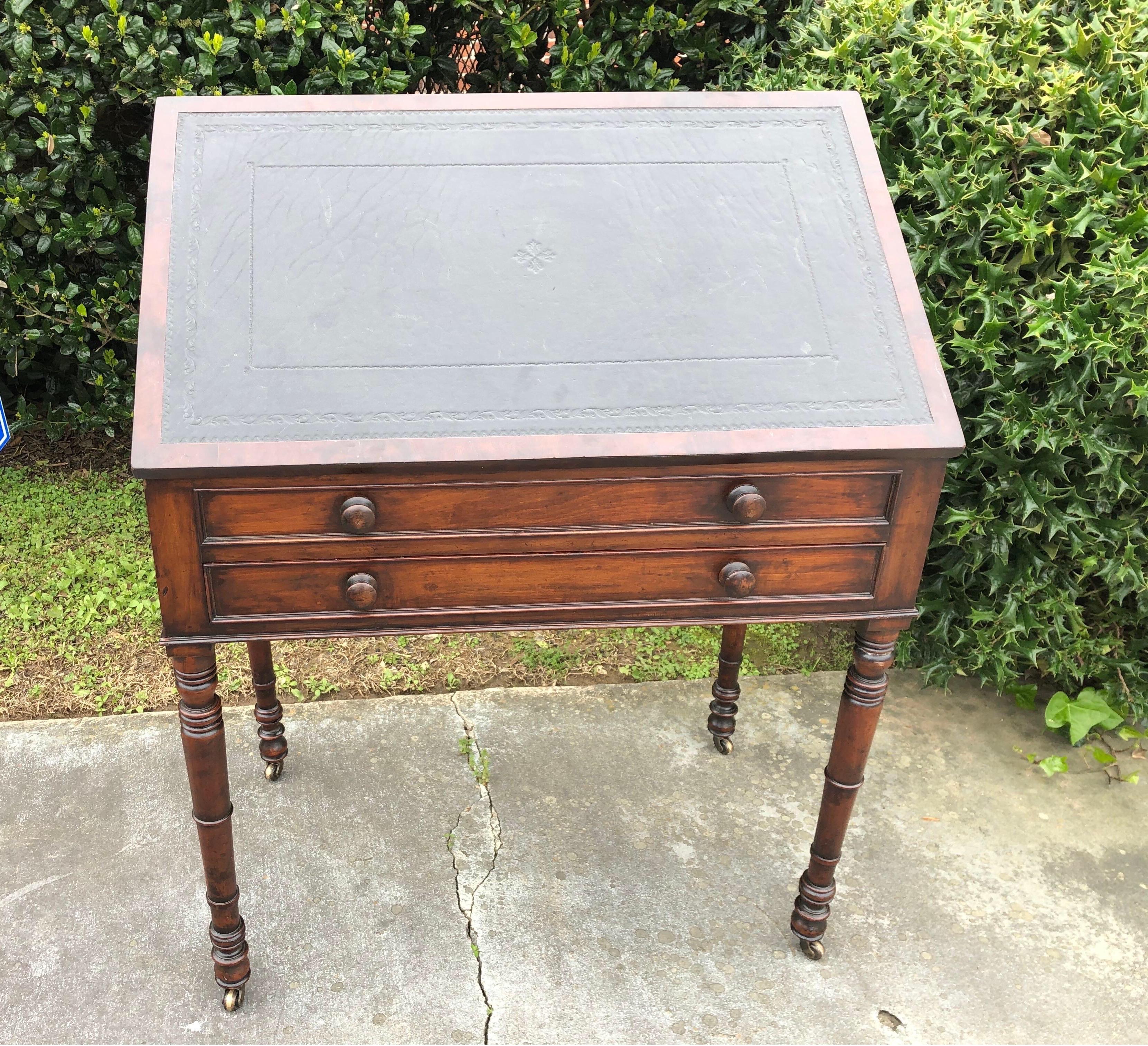 19th century English mahogany and leather top architect's style desk with
inset tooled leather lift top, adjustable easel support, one-drawer under fixed drawer, ring-turned legs and casters.