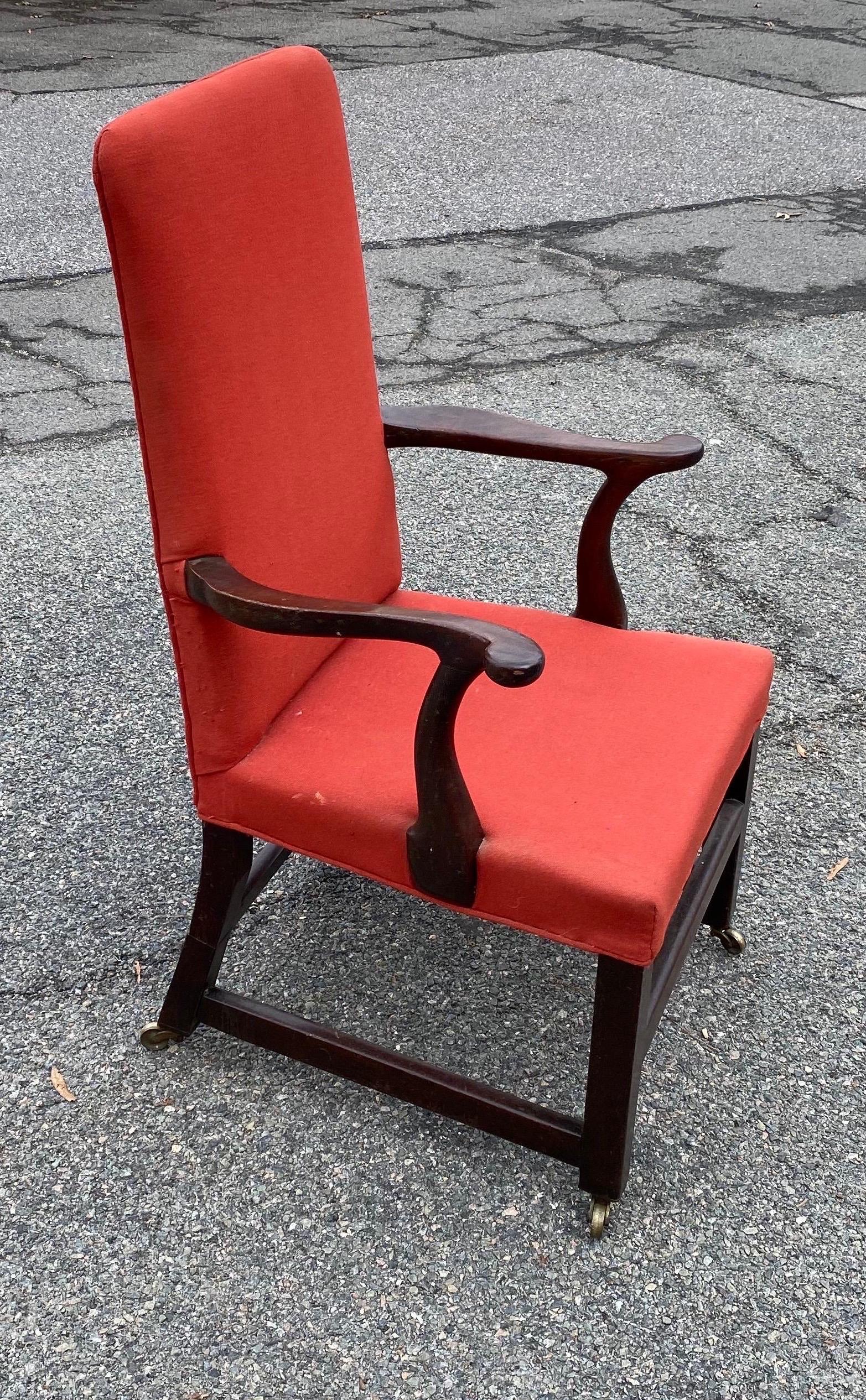 Lovely 19th century English mahogany armchair in red upholstery and castors. Chair has charming old restorations to the back legs, appearing as cuffs.