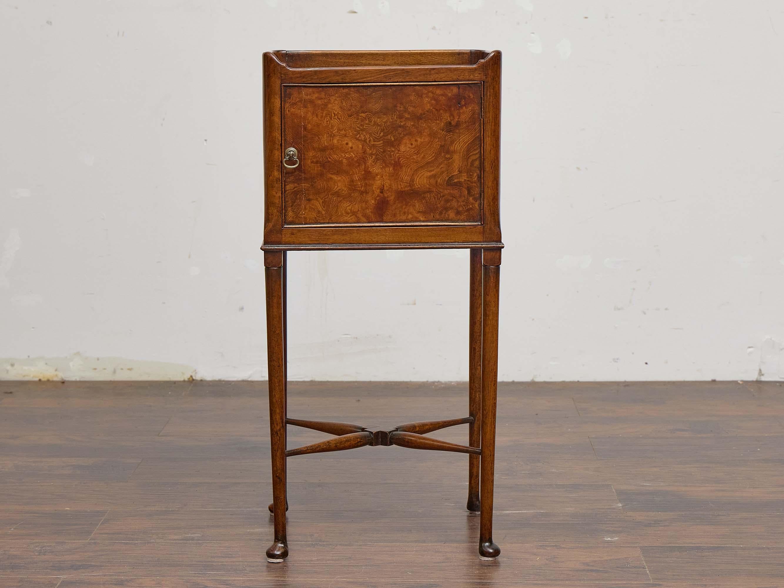 Questo mobile inglese in mogano del XIX secolo poggia su eleganti gambe affusolate con piedi a pad e presenta una cassa quadrata dotata di un'unica anta, impiallacciata in mogano di radica riccamente figurato. Le proporzioni compatte (14,25