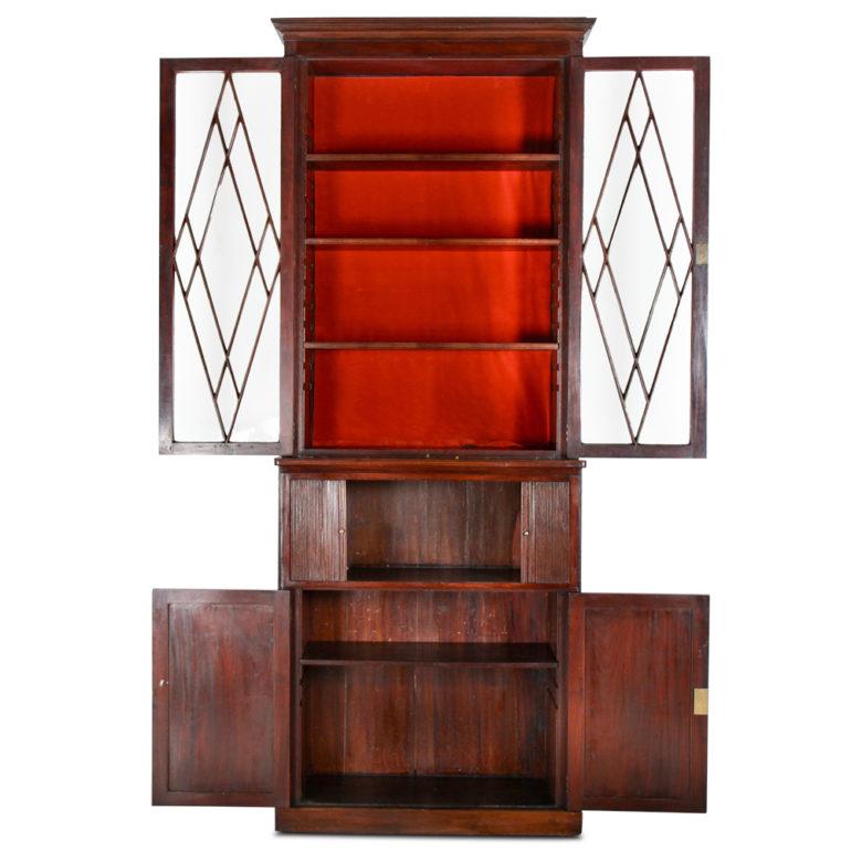 Unusual and elegant 19th century English mahogany bookcase with diamond pattern glazing to the upper bookcase, a tambour-front middle section and a two door lower cabinet / cupboard.
The glass-fronted section has four adjustable shelves.

