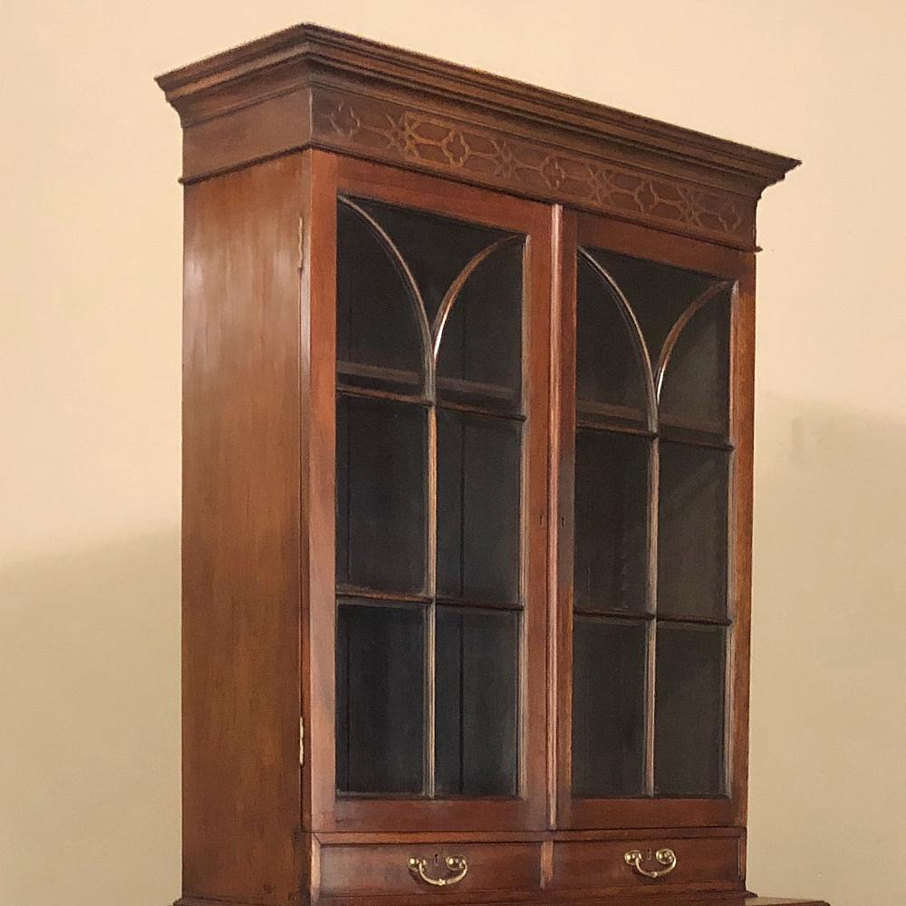 19th century English mahogany bookcase is a stellar example of the genre, with neoclassic styling in an interpretation that is purely British! The multi-tiered crown is adorned with a bas relief pattern of alternating quatrefoils and four-pointed