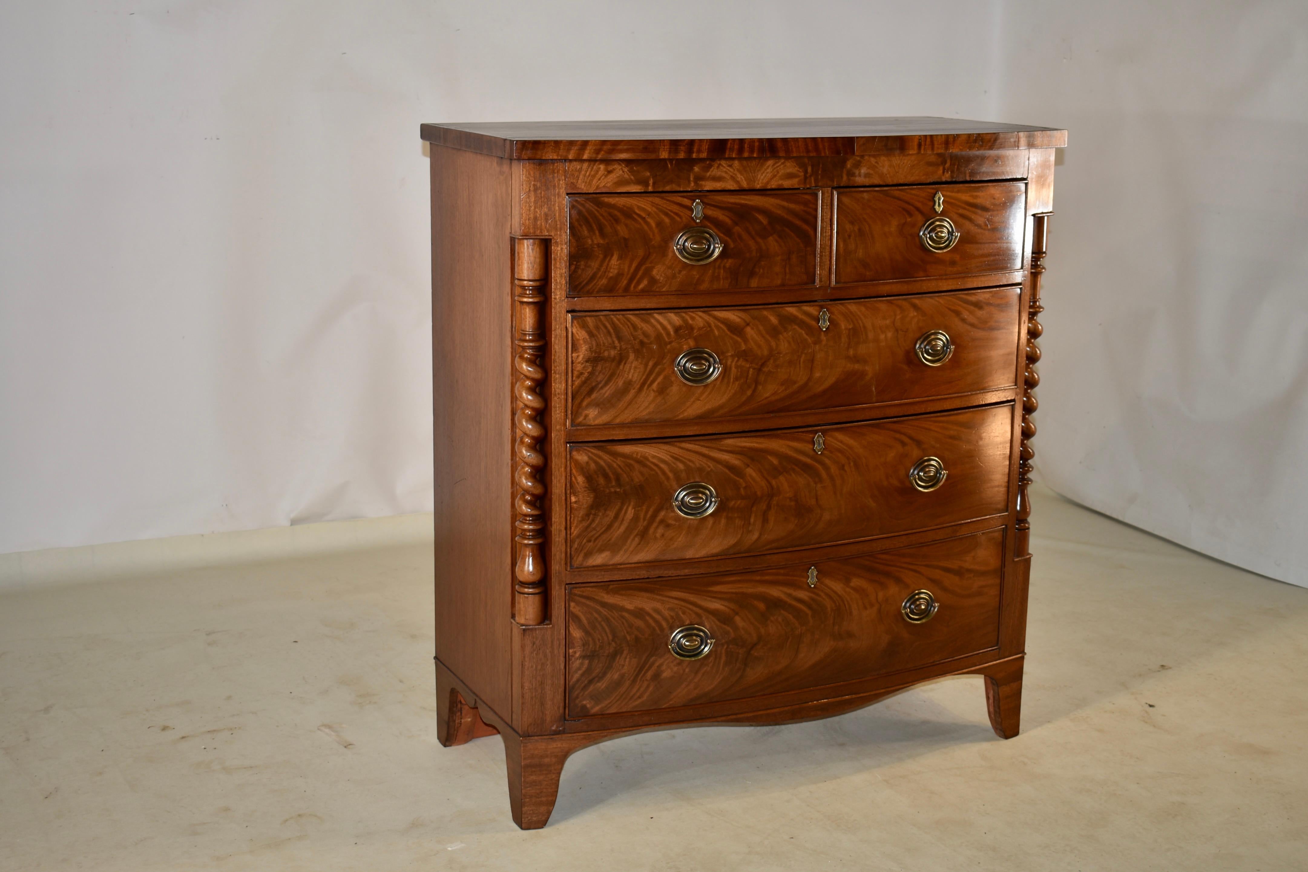 19th century mahogany bow front chest of drawers from England. This chest has fantastic graining and color throughout. The top is beautifully grained and follows down to simple sides and two drawers over three drawers in the front, flanked by turned