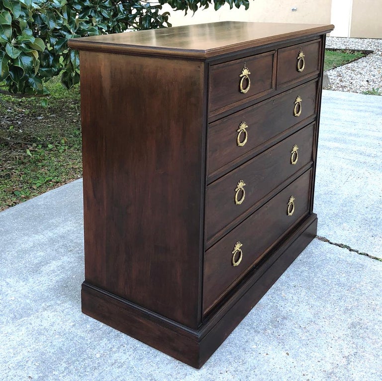 19th century English mahogany chest of drawers provides a tailored architecture and copious storage that will be a welcome addition to any room! Handcrafted from exotic imported mahogany, it boasts intricately cast brass ring pulls,

circa