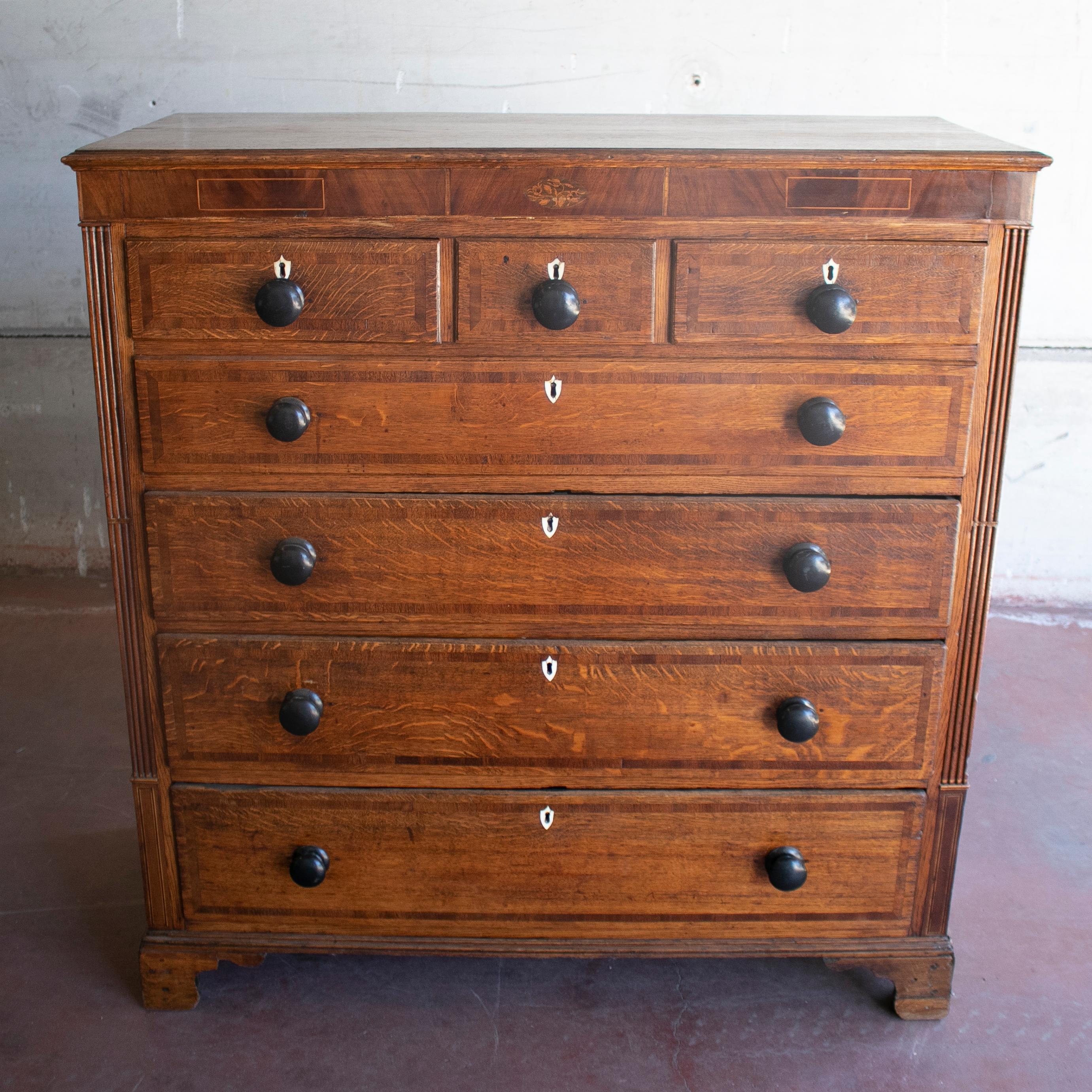 19th century English mahogany chest of drawers with wood inlay decorations.