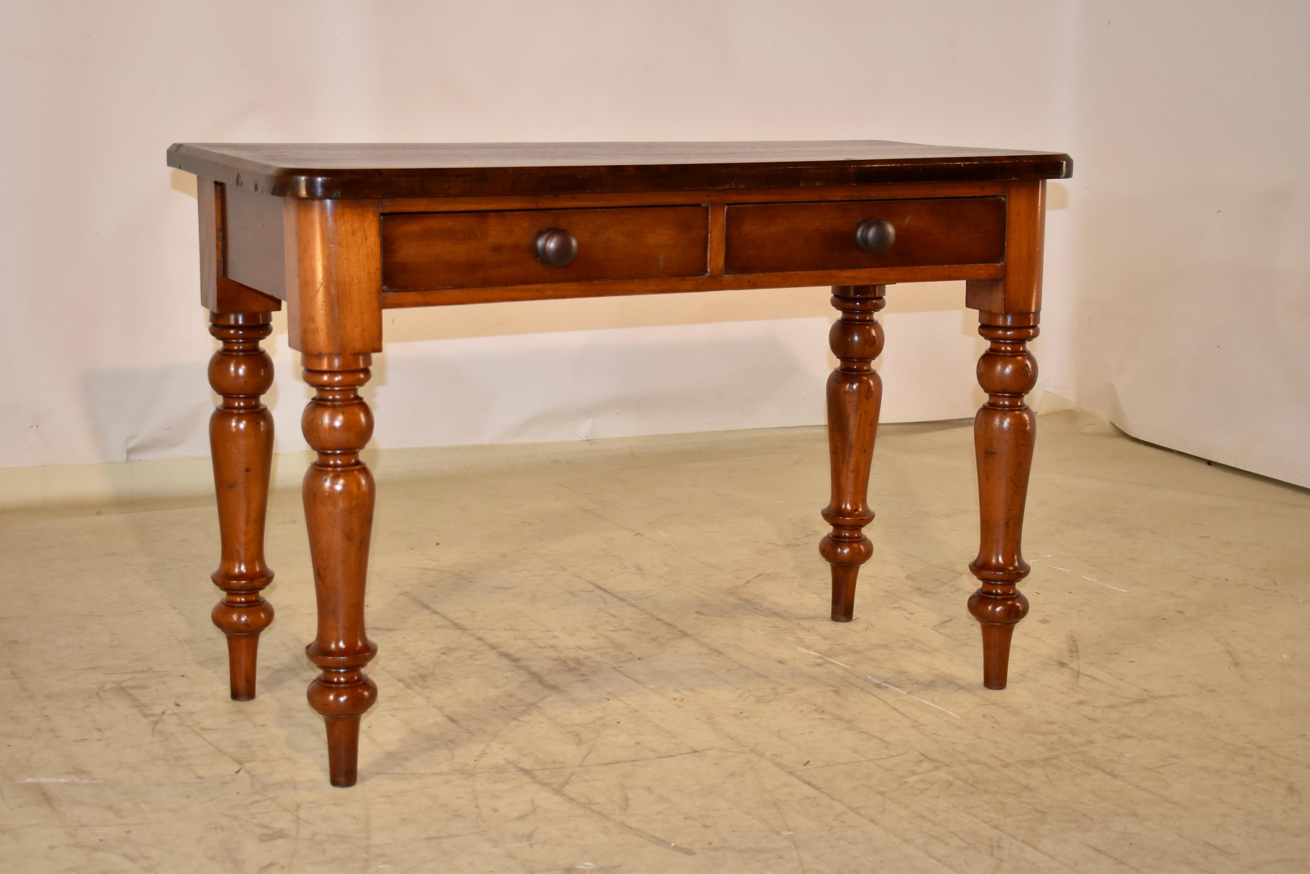 19th Century mahogany console table from England with a beveled edge around the top.  This follows down to a simple apron which contains two drawers in the front and simple sides.  The piece is raised on hand turned legs.  The legs are wonderfully