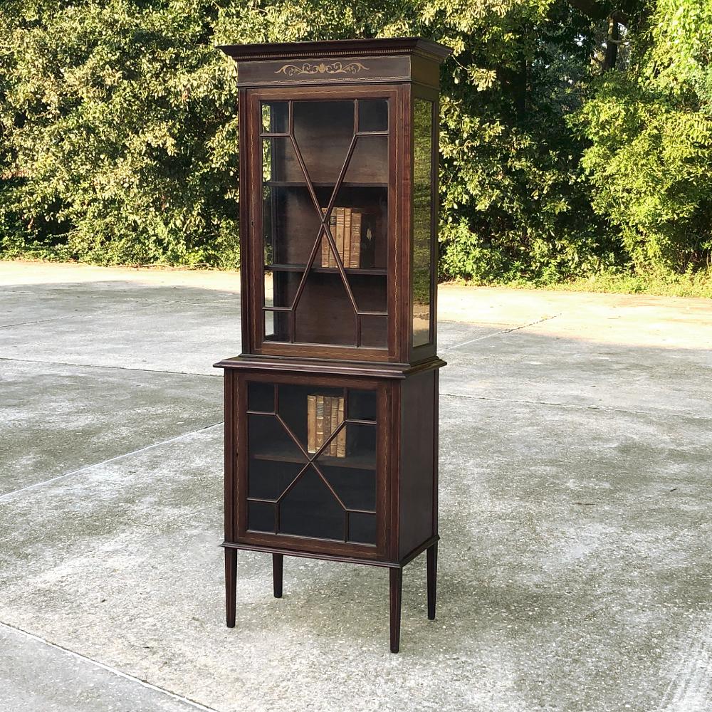 19th century English mahogany Curio cabinet features an intriguing two tiered design, with ample glazing above and below to show off your prized possessions and cherished family heirlooms in style! Glass on three sides of the upper tier means