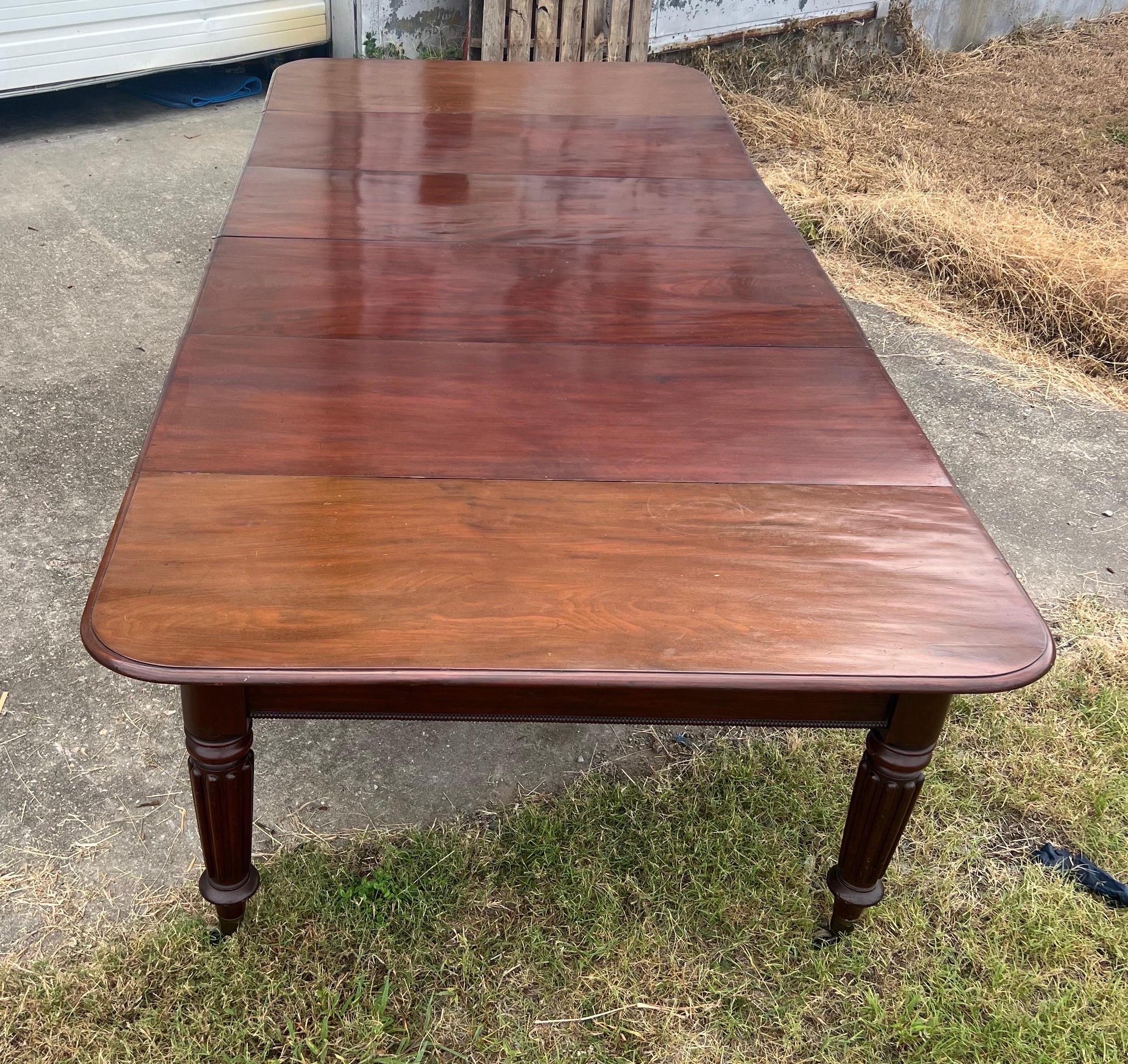 Impressive size and scale on this period 19th century English mahogany dining table, likely by made by Gillows in the 1st half of the 19th century. The table comes together similarly to the 