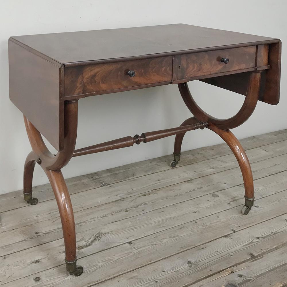 19th century English mahogany drop leaf desk, table is perfect as a writing desk, a sofa table, an occasional table, or even for a breakfast nook! Most often used in offices as an ancillary desk, it has been crafted from exotic imported mahogany